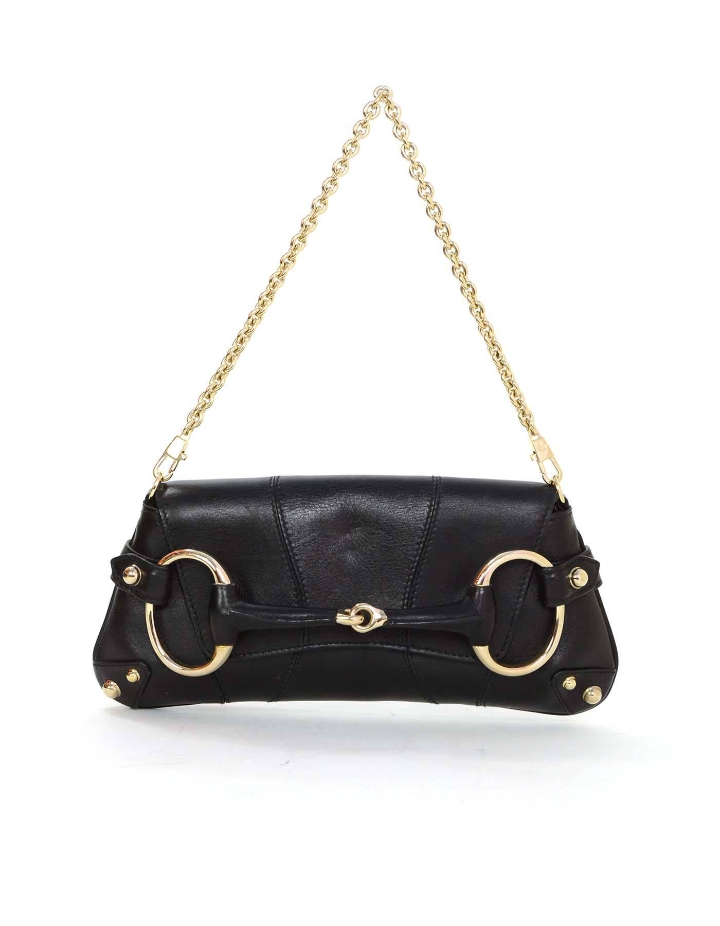 Gucci Black Leather Horsebit Clutch 
Features optional chainlink strap
Made In: Italy
Color: Black
Hardware: Goldtone
Materials: Leather
Lining: Black textile
Closure/Opening: Flap top that tucks into horsebit hardware
Exterior Pockets: