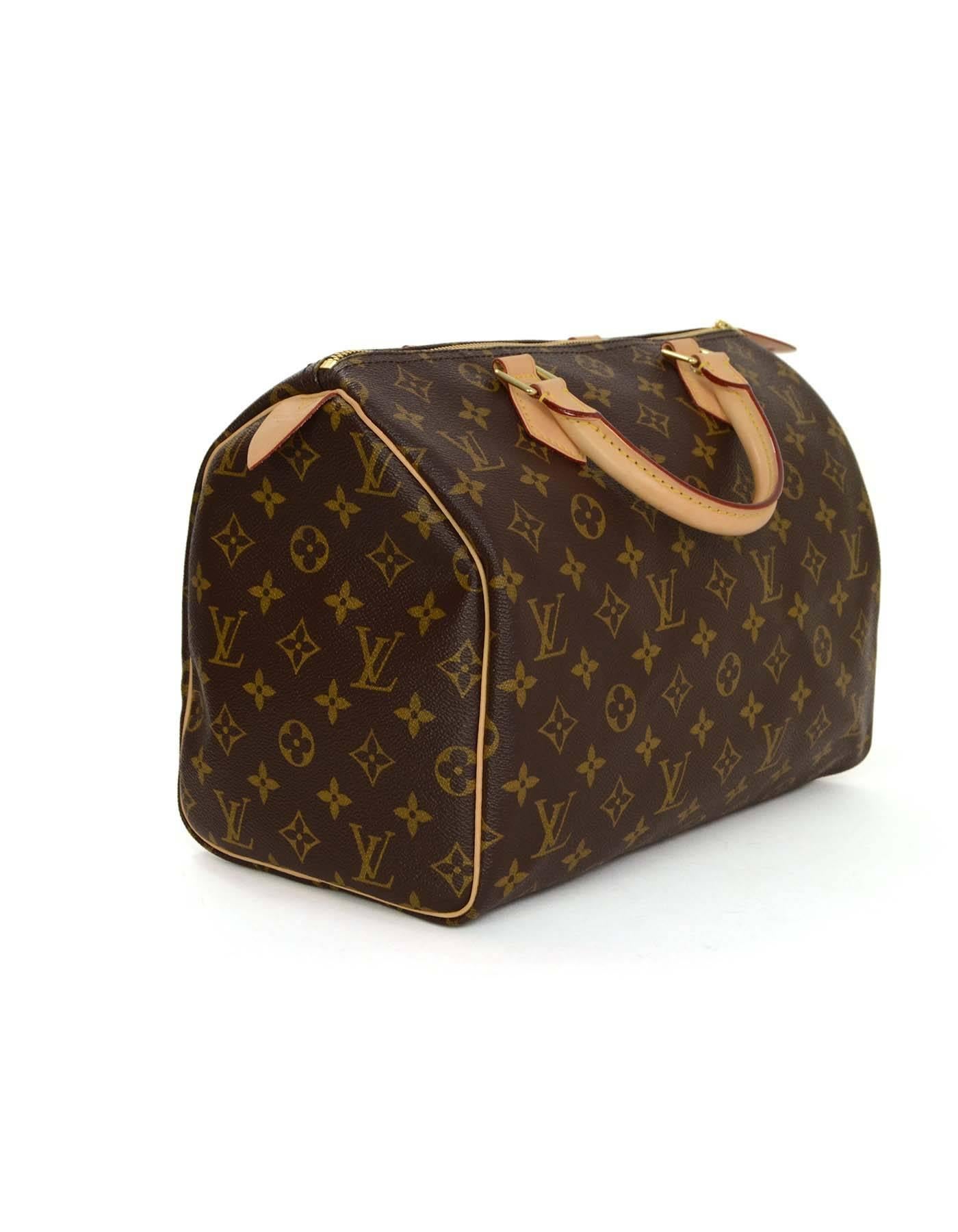 Louis Vuitton Monogram Speedy 30 Bag
Features leather rolled handles and leather trim/piping
Made in: U.S.A
Year of Production: 2015
Color: Brown and tan
Hardware: Goldtone
Materials: Coated canvas and leather
Lining: Brown