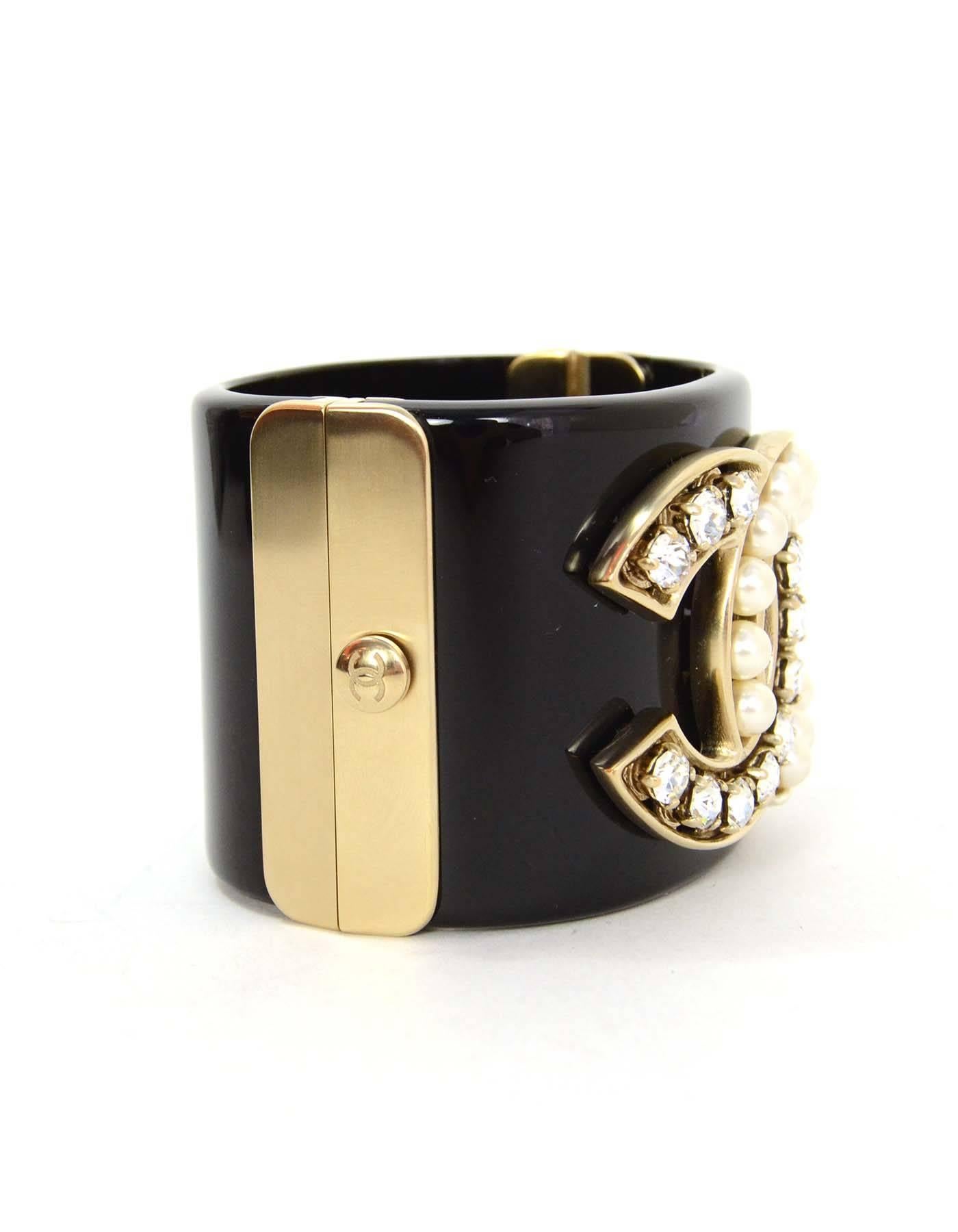 Chanel Crystal & Pearl CC Cuff
Features pearl and crystal detailing throughout CC
Made In: Italy
Year of Production: 2014
Color: Black, pale gold, and ivory
Materials: Resin, metal, faux pearl and crystal
Closure: Push lock closure
Stamp: B14
