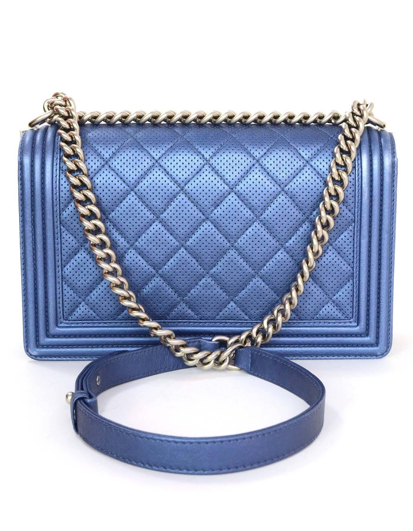Chanel Metallic Blue Perforated New Medium Boy Bag 
Features adjustable shoulder strap and quilting throughout
Made In: Italy
Year of Production: 2015
Color: Iridescent blue
Hardware: Matte silvertone
Materials: Perforated leather
Lining: