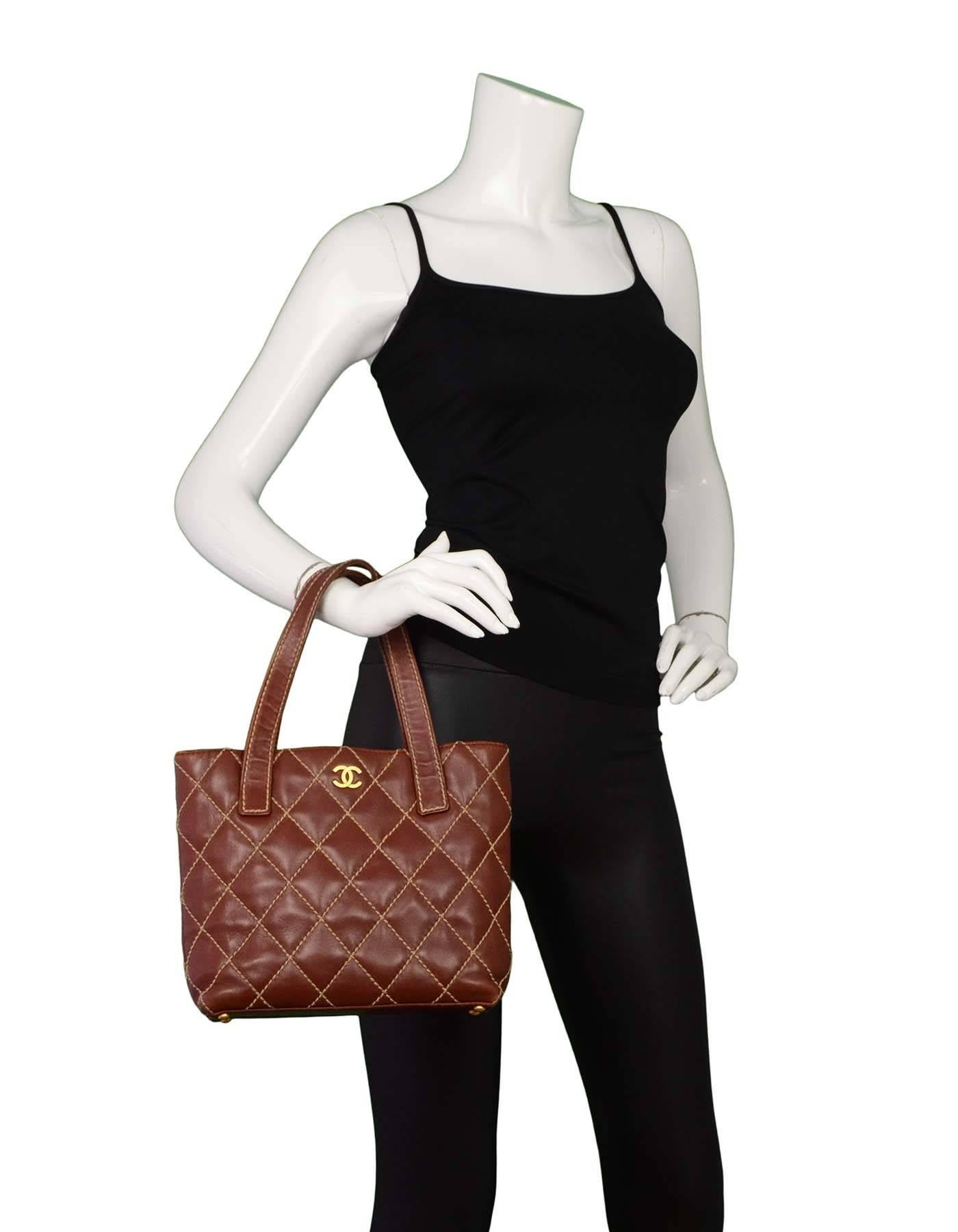 Chanel Brown Quilted Surpique Small Tote
Features CC logo at front and tan contrast stitching

Made In: France
Year of Production: 2003-2004
Color: Brown
Hardware: Goldtone
Materials: Leather
Lining: Brown logo textile
Closure/Opening: