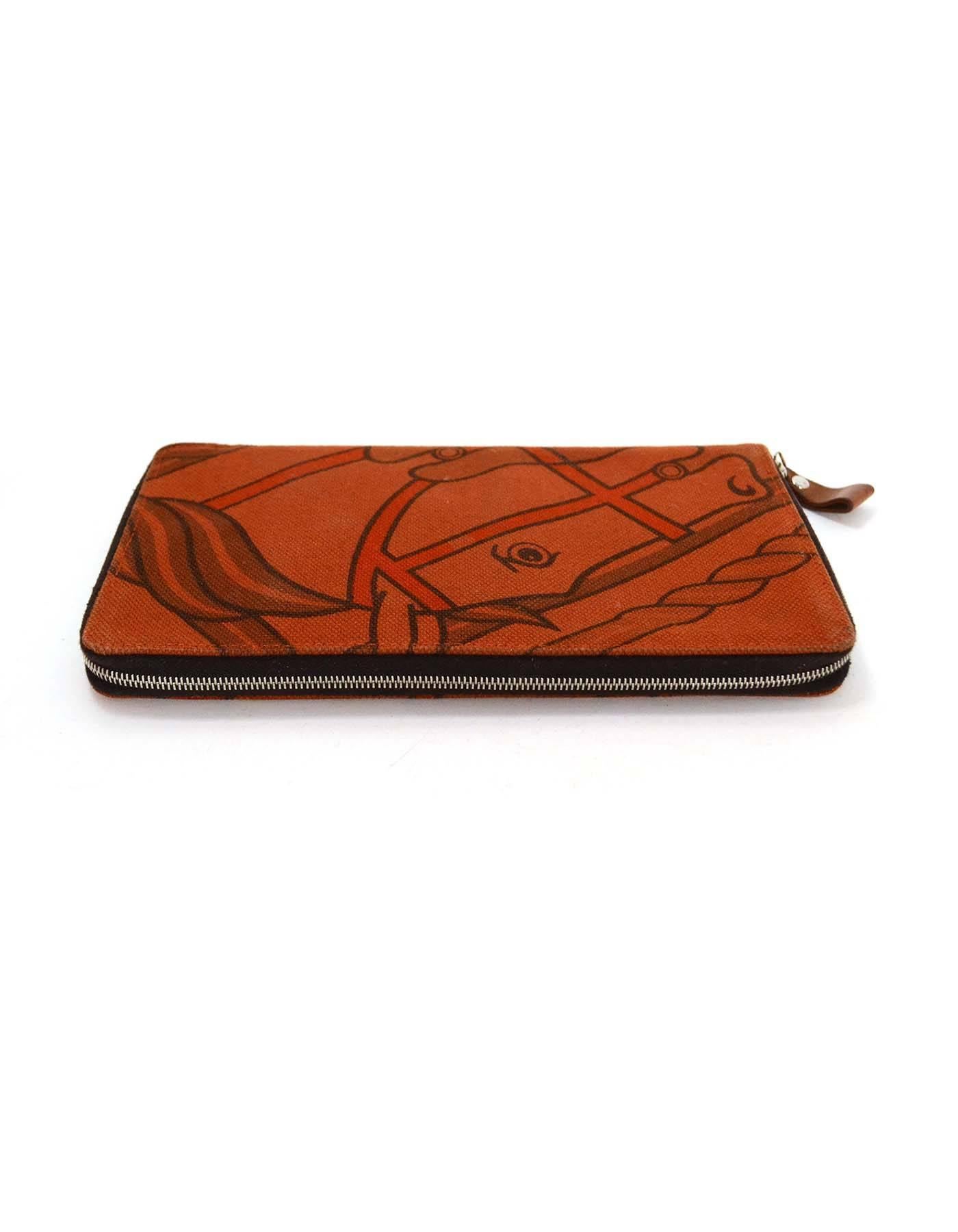 Hermes Horse Print Canvas Oversize Wallet

Made in: France
Year of Production: 2012
Color: Burnt orange and brown
Materials: Canvas
Hardware: Silvertone
Lining: Brown textile
Exterior Pockets: None
Interior Pockets: Ten card slots, three
