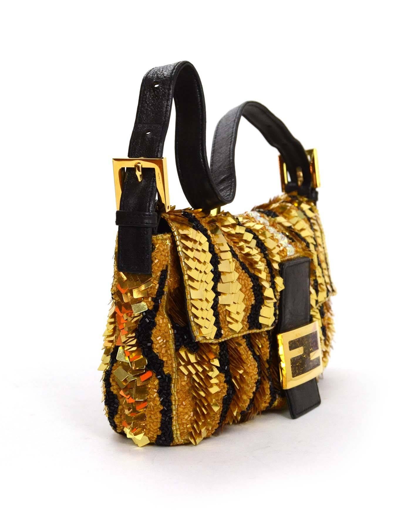 Fendi Gold & Black Sequin Baguette
Features detachable black leather shoulder strap
Made In: Italy
Color: Gold and black
Hardware: Goldtone
Materials: Leather, beads and sequins
Lining: Black satin
Closure/Opening: Flap top with magnetic snap