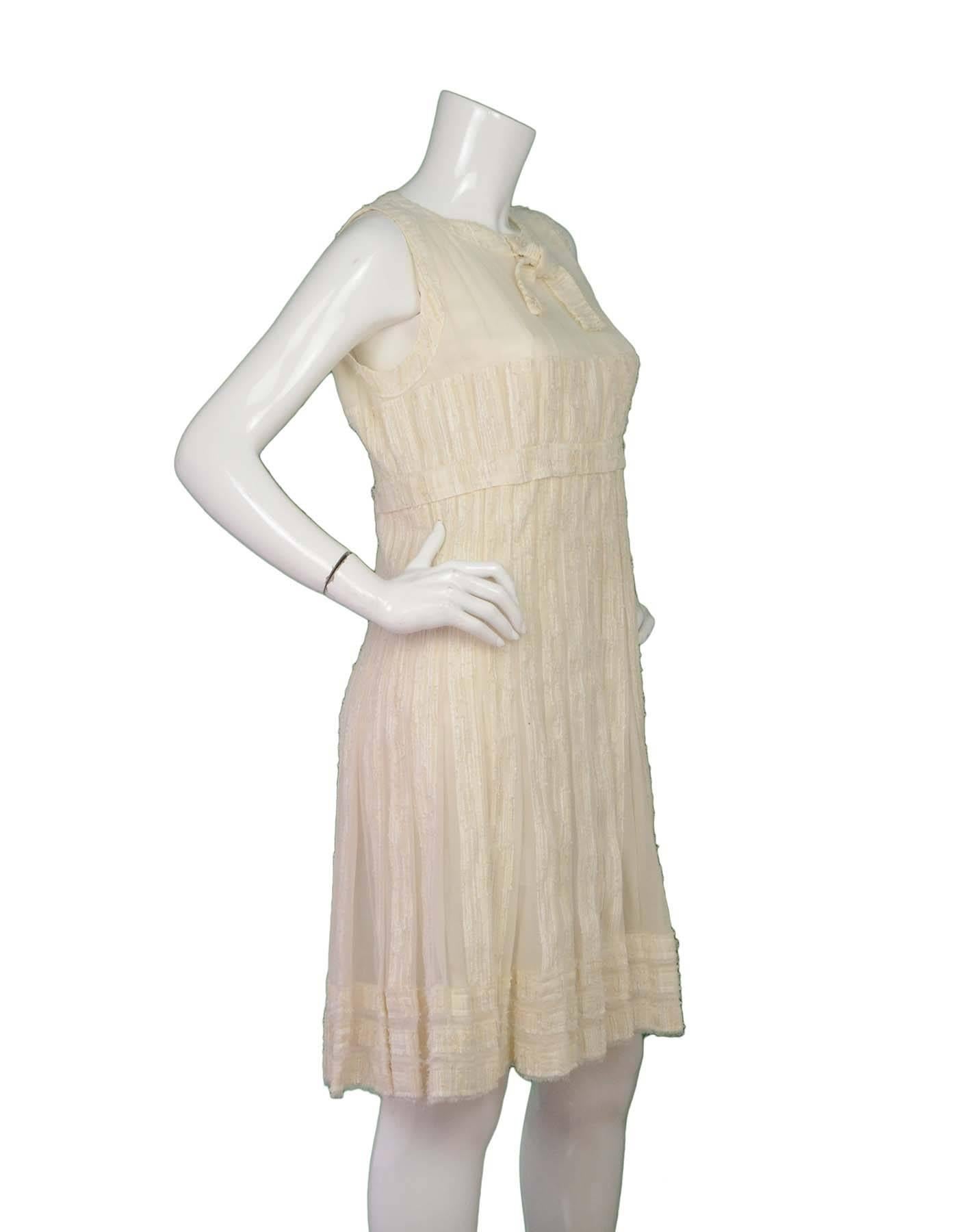 Chanel Cream Silk Dress Sz 42

Features necktie and silver detail threading throughout

Made In: France
Year of Production: 2007 Cruise
Color: Cream and silver
Composition: 100% Silk
Lining: Silk lining at waist down
Closure/Opening: Button