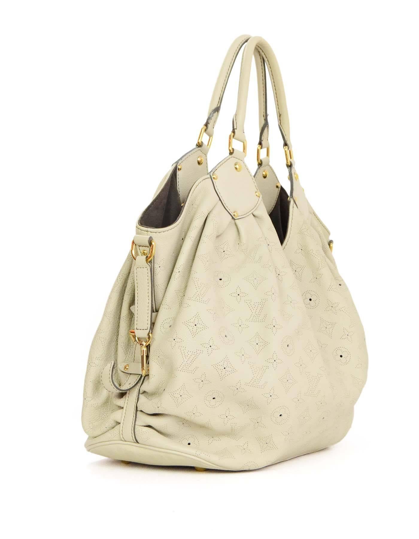 Features perforated monogram

    Made In: France
    Year of Production: 2007
    Color: Ivory
    Hardware: Goldtone
    Materials: Leather
    Lining: Brown alcantara
    Closure/Opening: Open with leather flap tab and push lock closure
