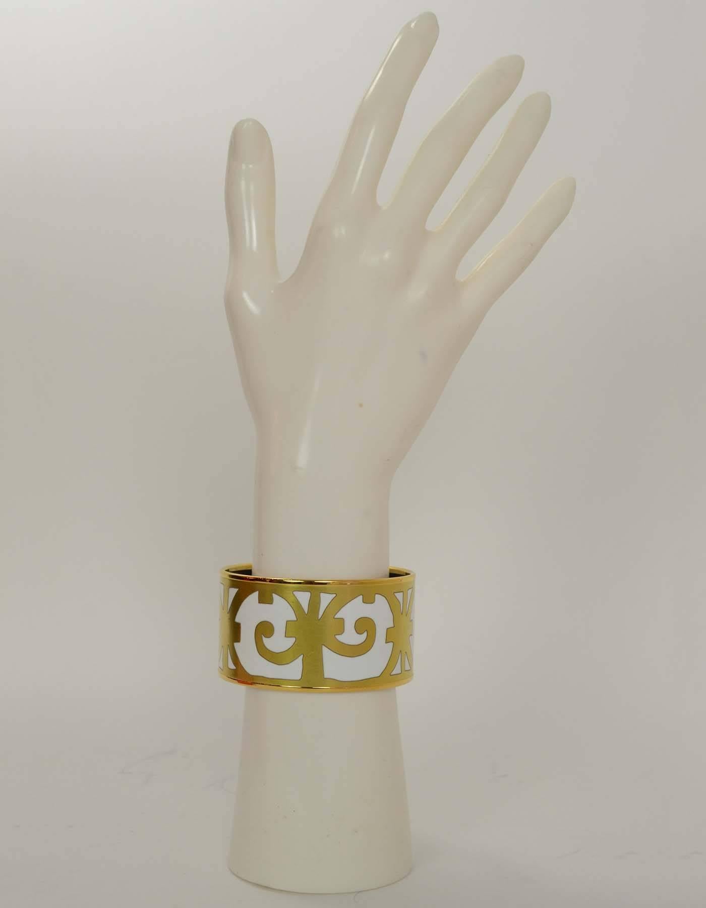 Hermes White & Gold Balcons du Guadalquivir Extra Wide Bracelet Sz 65

Made in: France
Stamp: Made in France + T
Closure: None
Color: White and gold
Retail Price: $700 + tax
Materials: Metal and enamel
Overall Condition: Excellent with the