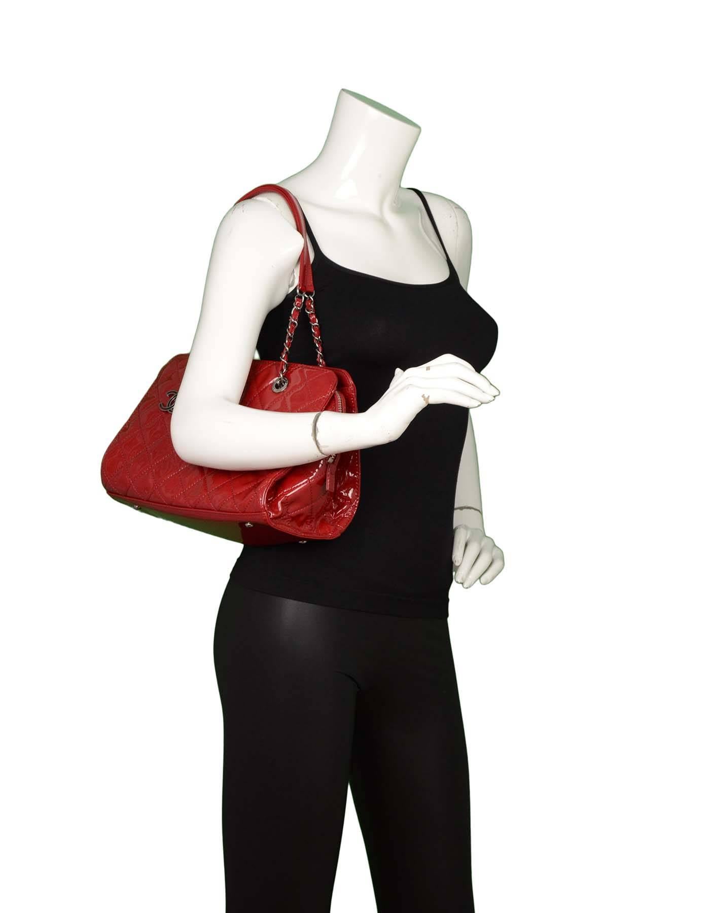 Chanel Red Patent Leather Tote
Features quilting throughout and CC charm

Made In: France
Year of Production: 2014
Color: Red
Interior Lining: Red textile
Hardware: Ruthenium
Materials: Patent leather
Closure/Opening: Center pocket double zip top