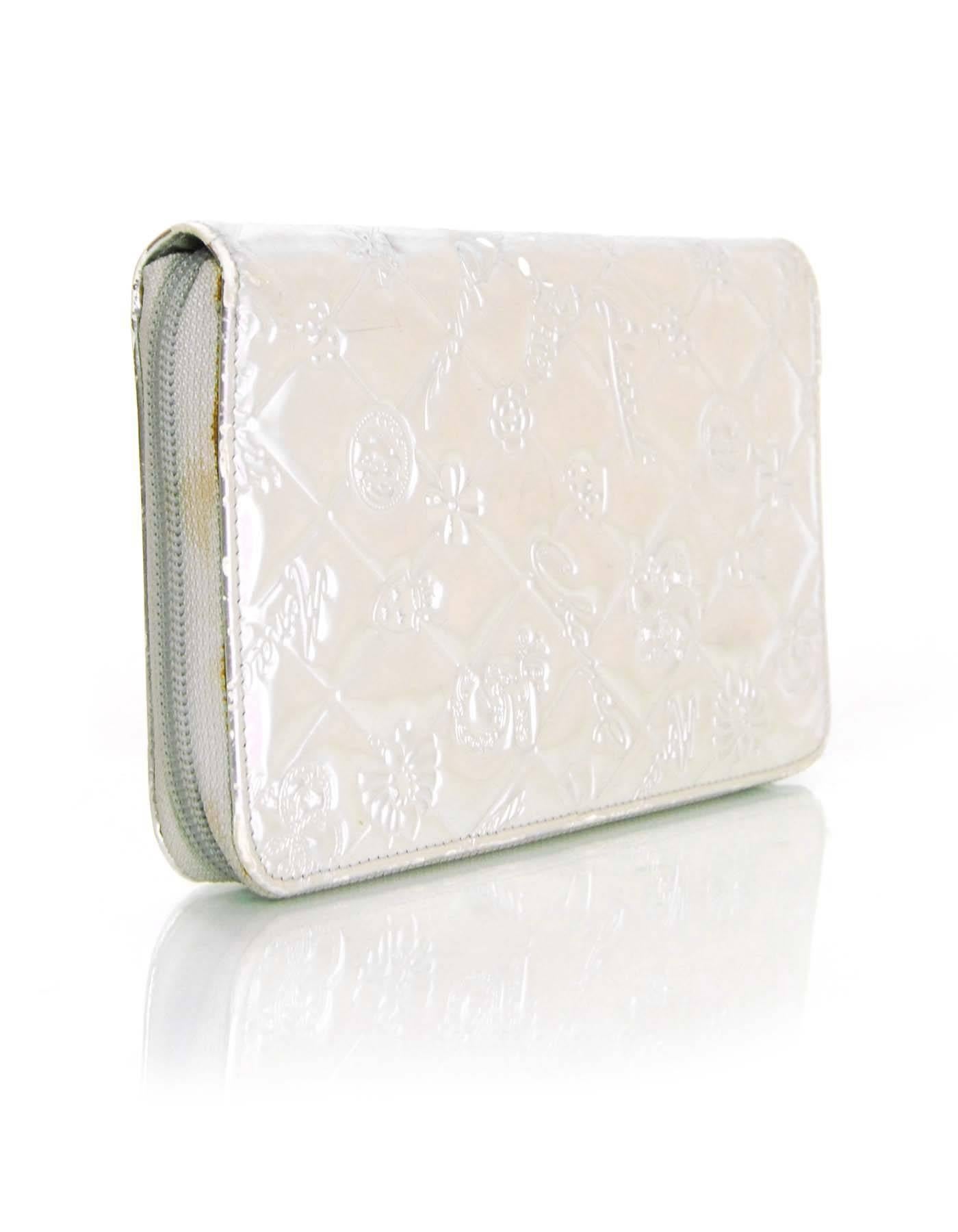 Chanel Silver Mirror Icons Zip Around XL Wallet
Features embossed design throughout

Made In: Italy
Year of Production: 2006-2008
Color: Silver
Hardware: Silvertone
Materials: Leather
Lining: Silver leather
Closure/Opening: Zip around