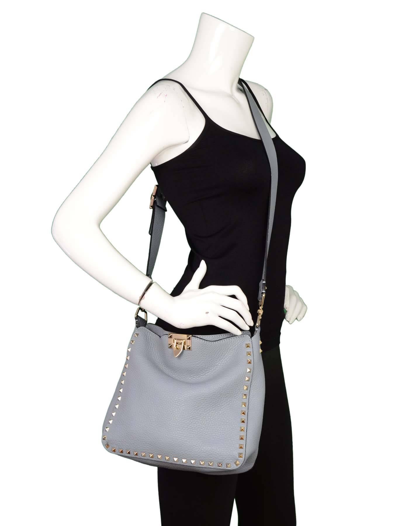Valentino Slate Blue Rockstud Crossbody Bag
Features adjustable shoulder strap

Made In: Italy
Color: Slate blue/grey
Hardware: Goldtone
Materials: Leather and metal
Lining: None
Closure/Opening: Open top with center flap lock
