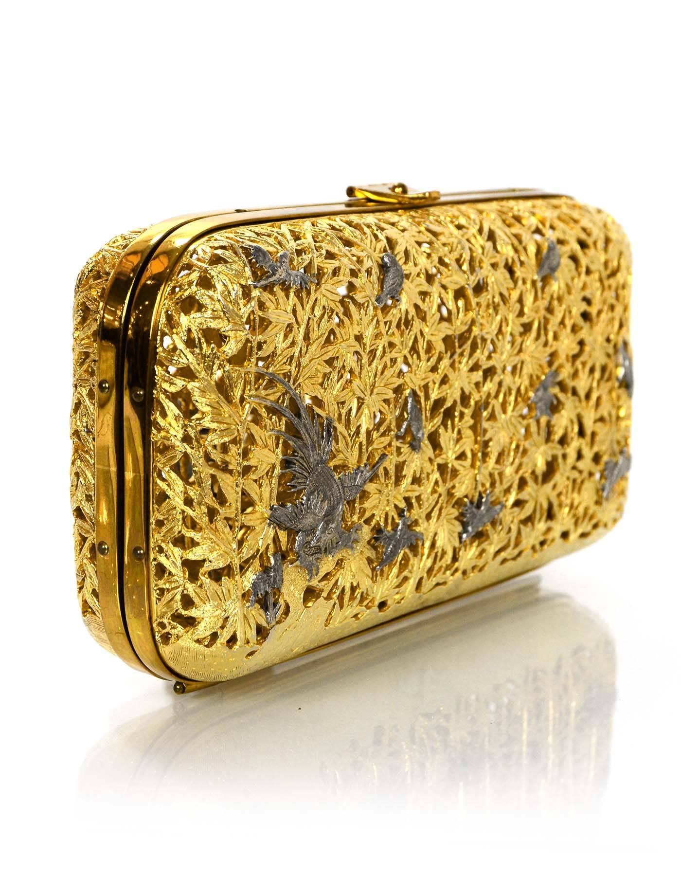 Judith Leiber Gold Metal Hard Case Minaudiere
Features birds and branches cut out in goldtone and gunmetal as well as optional shoulder strap

Color: Goldtone and gunmetal
Hardware: Goldtone
Materials: Metal
Lining: None
Closure/Opening: