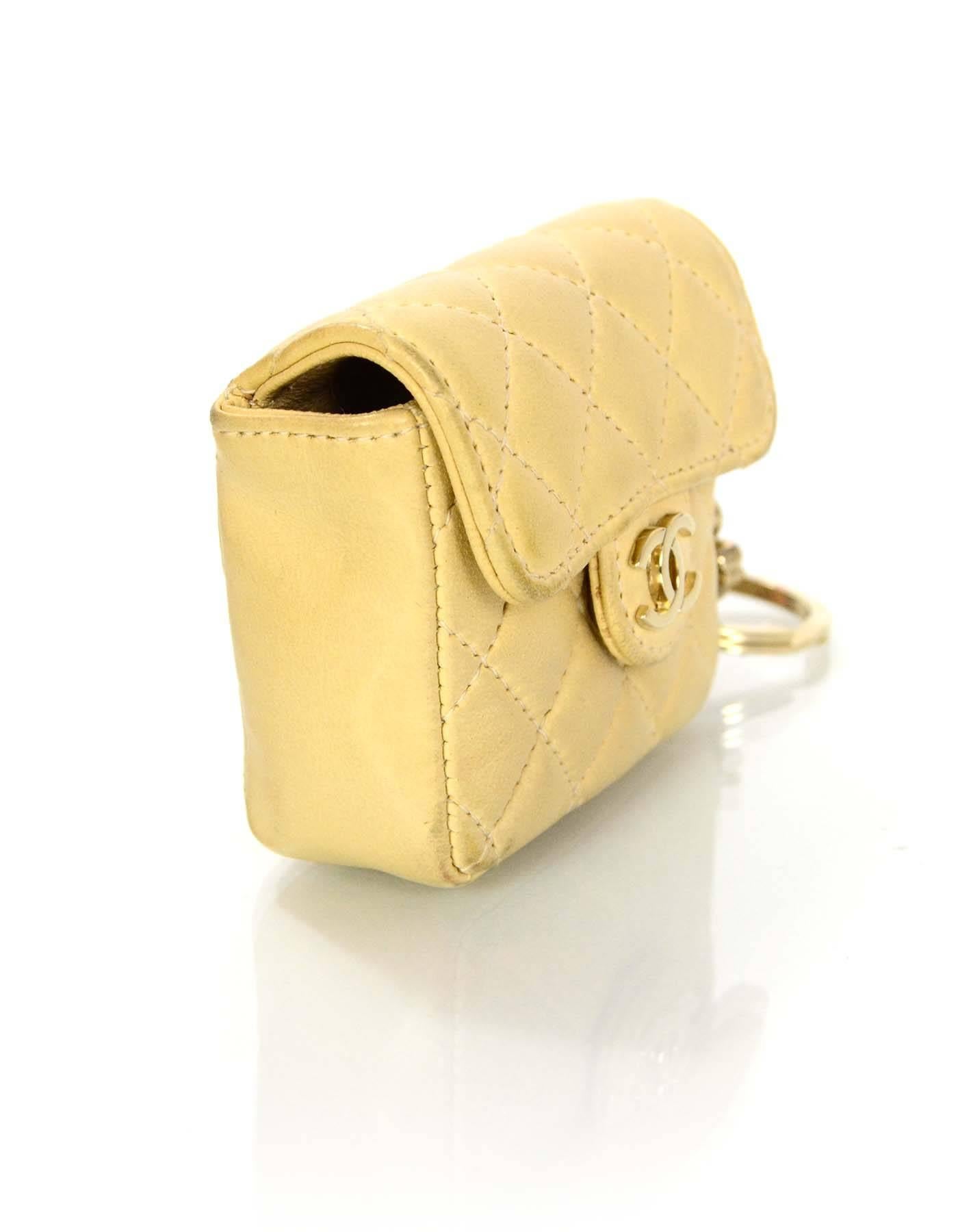 Chanel Beige Quilted Mini Flap Bag Key Ring 
Features iconic Coco, CC and four leaf clover charms attached

Made In: France
Year of Production: 2002-2003
Color: Beige
Hardware: Goldtone
Materials: Lambskin leather and metal
Lining: Beige