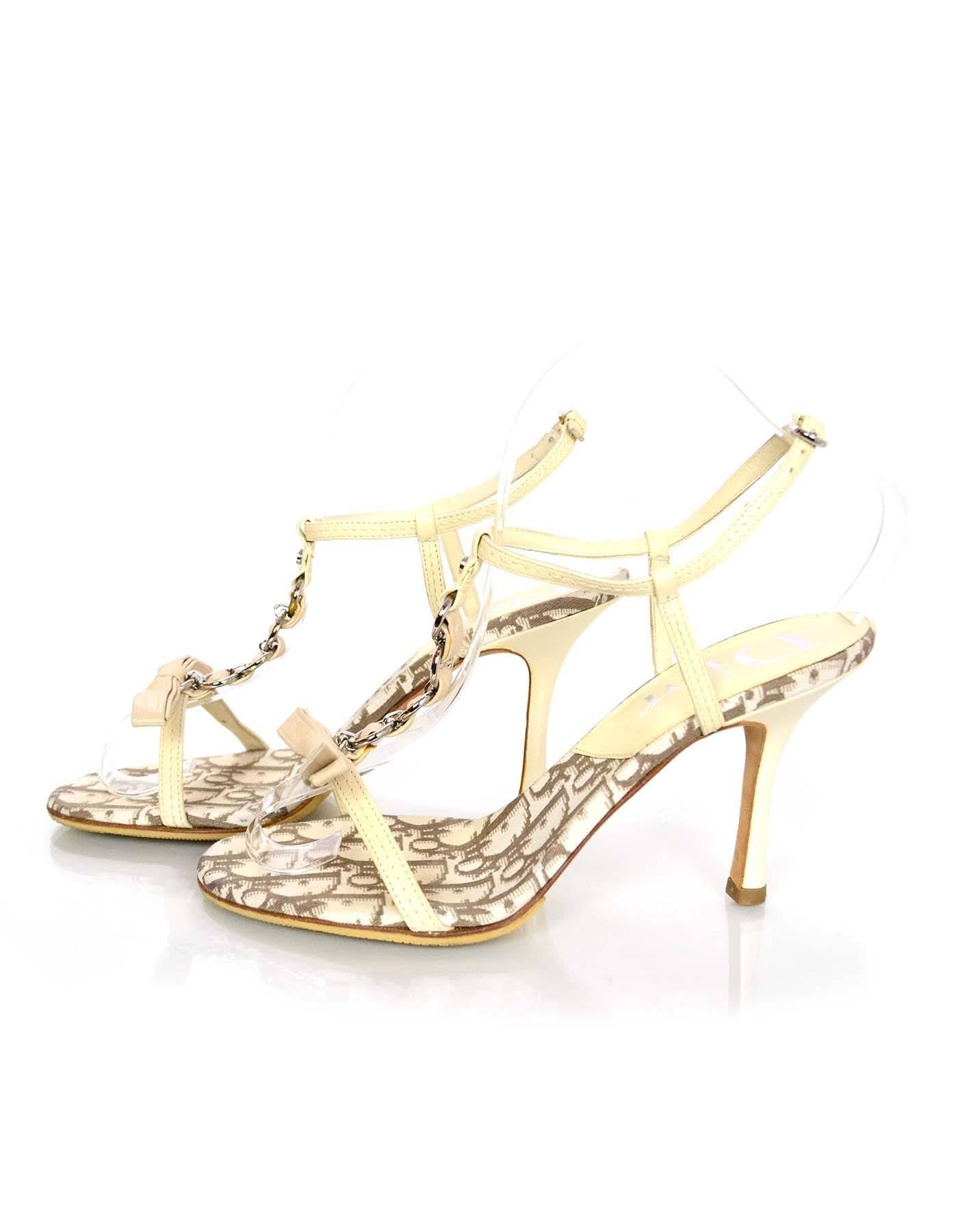 Christian Dior Cream T-Strap Sandals Sz 36.5
Features bow detail at toes

Made In: Italy
Color: Cream/Ivory
Materials: Leather and metal
Closure/Opening: Buckle closure at ankle
Sole Stamp: Dior Made in Italy 36.5
Overall Condition:
