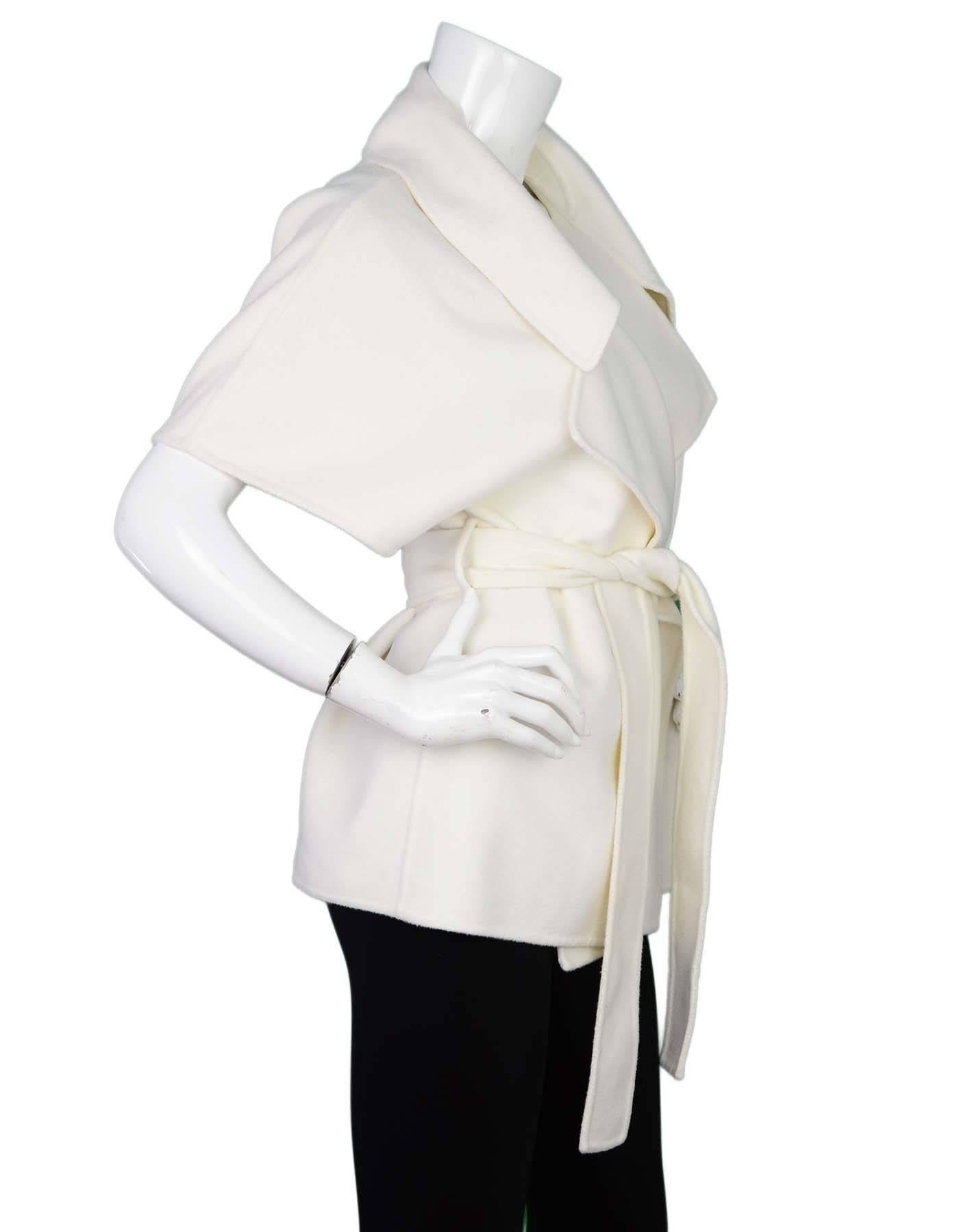 Gucci Cream Cap-Sleeve Jacket Sz 46
Features draped lapels

Made In: Italy
Color: Cream
Composition: 68% Wool, 32% Angora
Closure/Opening: Open front with tie belt at waist
Exterior Pockets: None
Interior Pockets: None
Overall Condition: