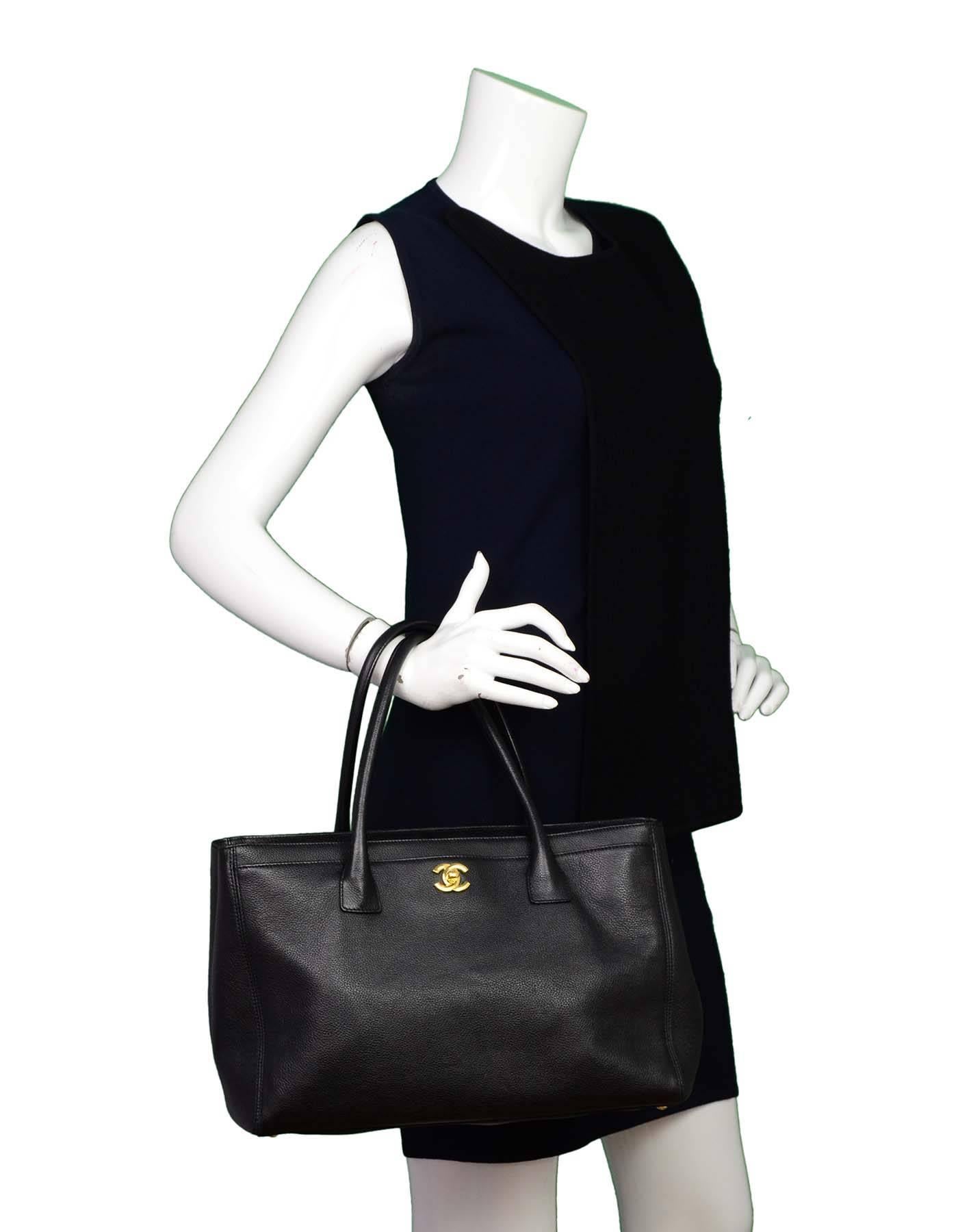 Chanel Black Leather Cerf Executive Tote
Features shoulder strap

Made In: Italy
Year of Production: 2011
Color: Black
Hardware: Goldtone
Materials: Leather, metal
Lining: Black textile
Closure/Opening: open top with center snap
Exterior