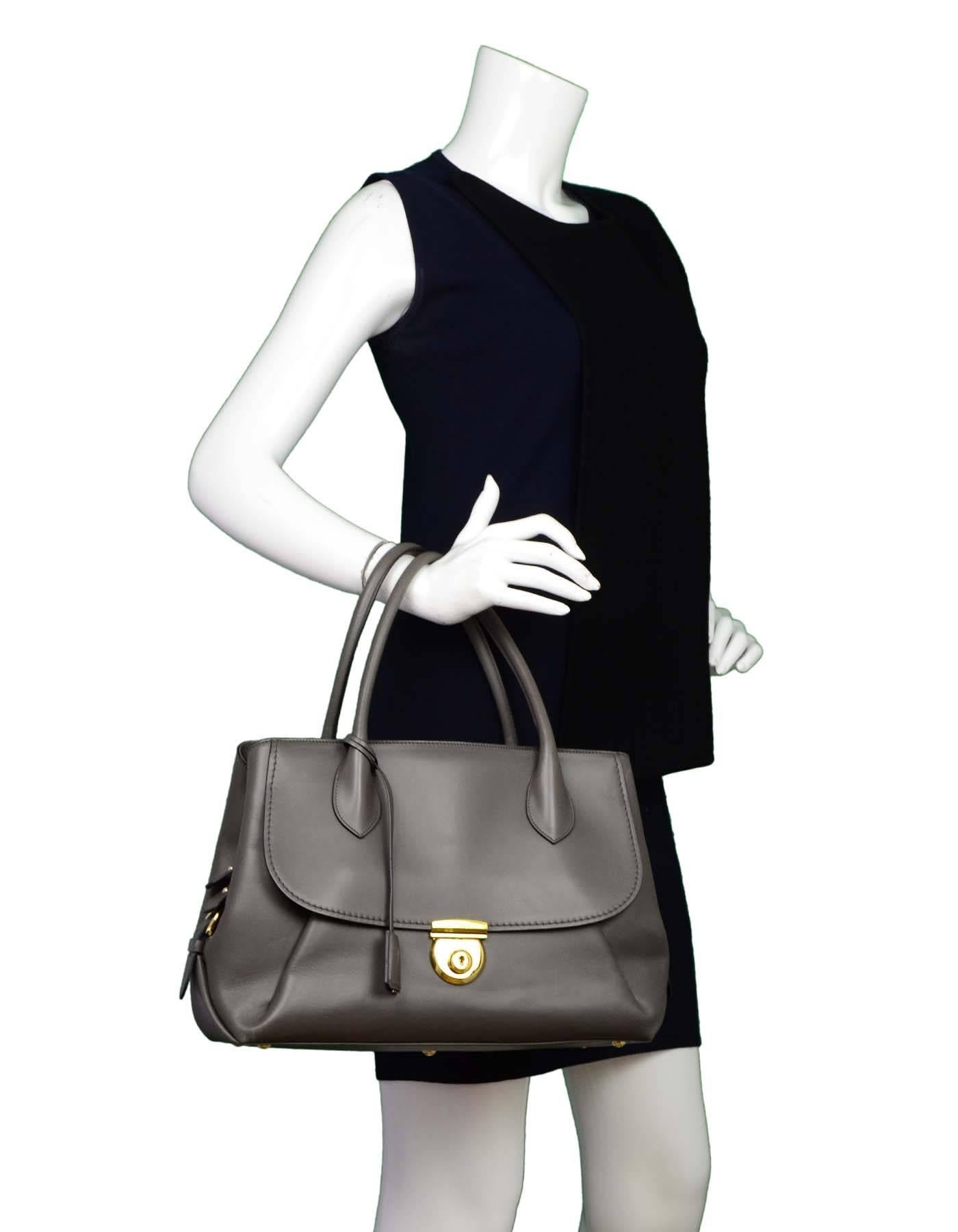 Salvatore Ferragamo Grey East/West Fiamma Tote

Made In: Italy
Color: Grey
Hardware: Goldtone
Materials: Leather and metal
Lining: Black textile
Closure/Opening: Open top
Exterior Pockets: Flap pocket at front ad zip pocket at back
Interior Pockets: