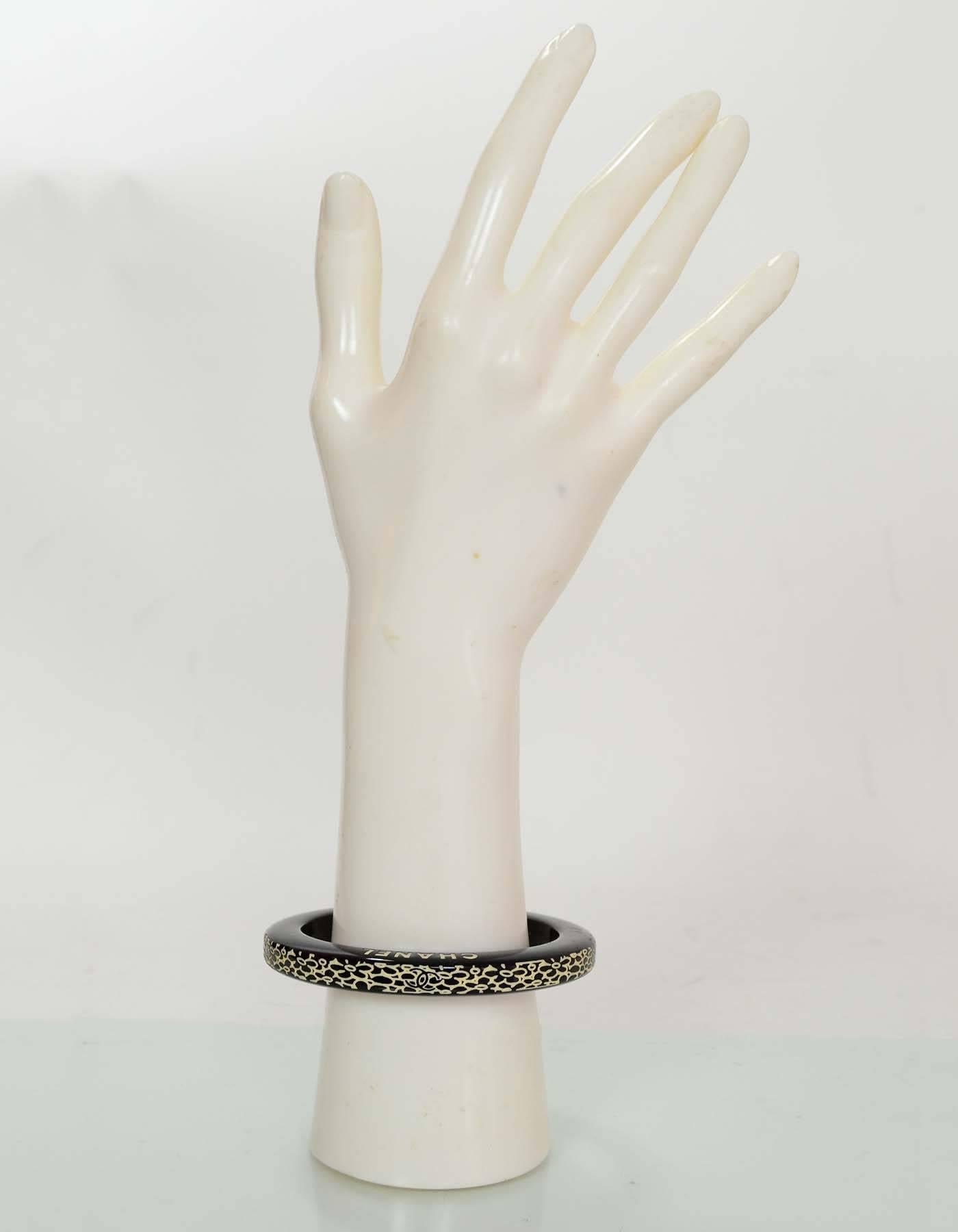 Chanel Black and White Resin Bangle

Made In: Italy
Year of Production: 2006 cruise
Color: Black and white
Materials: Resin
Closure: None
Stamp: Chanel 06 CC C Made in Italy
Overall Condition: Excellent Pre-Owned Condition with the exception