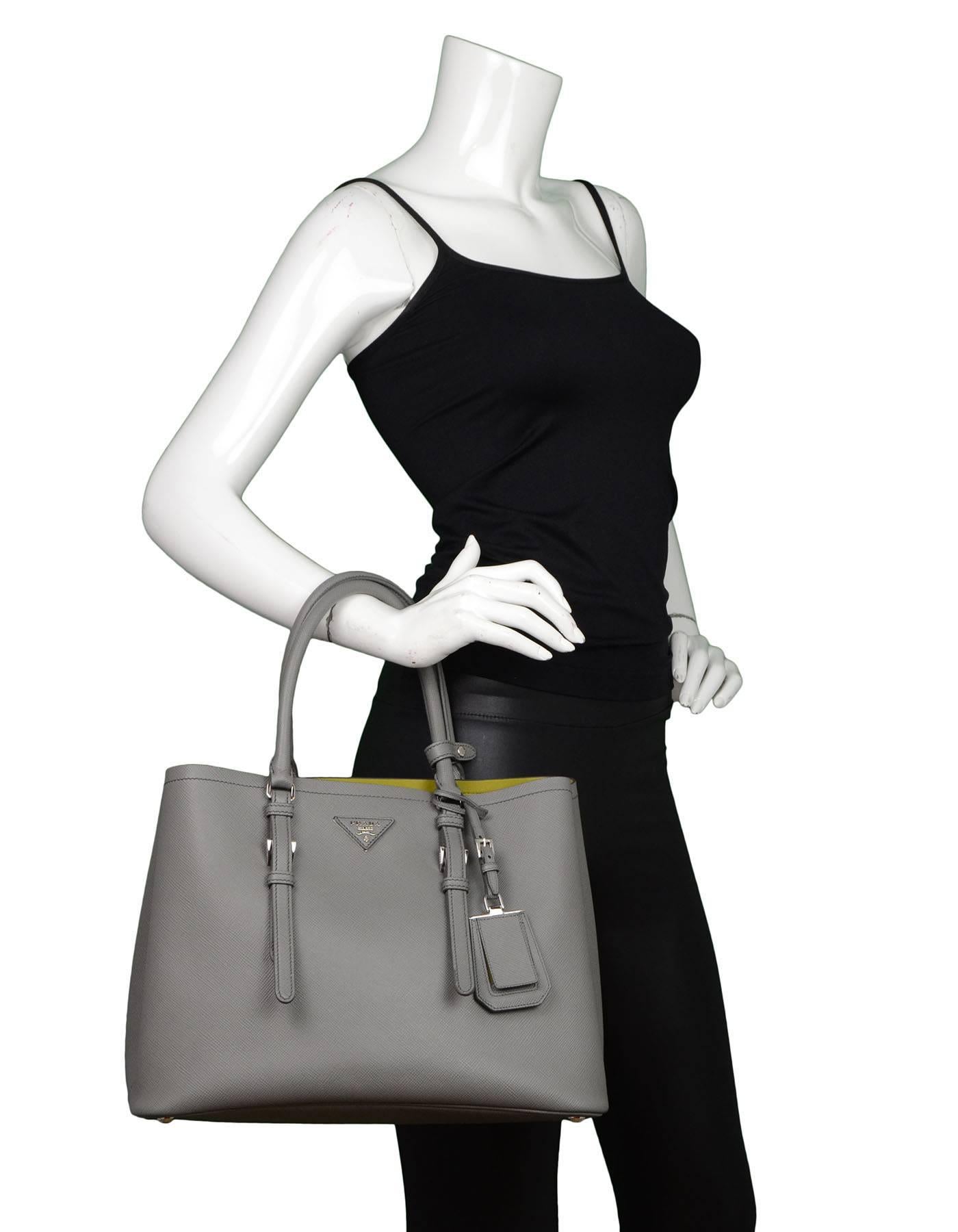 Prada Grey Saffiano Medium Double Tote 
Features contrast green leather interior and optional shoulder/crossbody strap

Made In: Italy
Year of Production: 2015
Color: Grey
Hardware: Silvertone
Materials: Saffiano leather
Lining: Green soft
