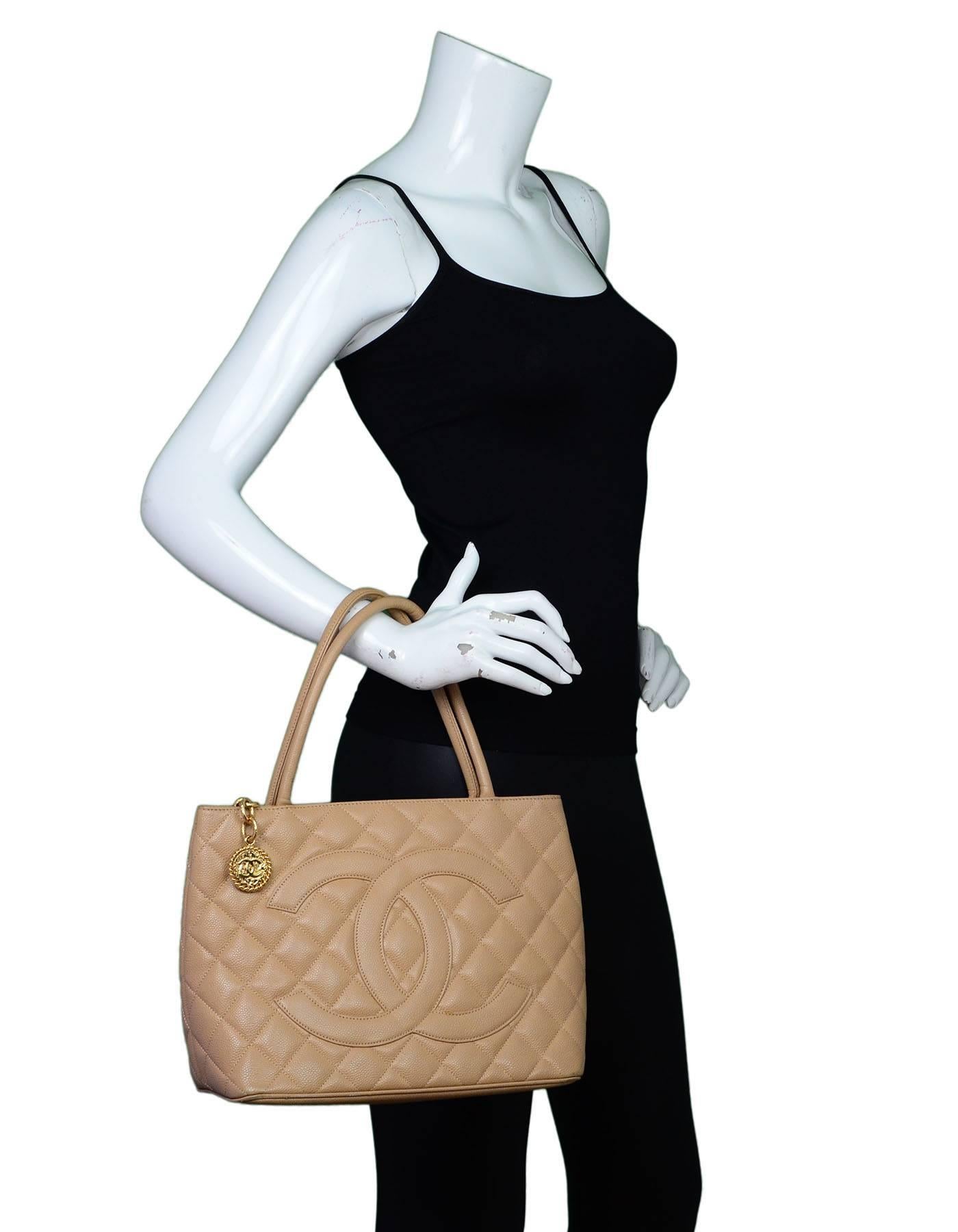 Chanel Beige Caviar Leather Medallion Tote
Features timeless CC at front and quilting throughout

Made In: Italy
Year of Production: 2002-2003
Color: Beige
Interior Lining: Beige leather
Hardware: Goldtone
Materials: Caviar leather,