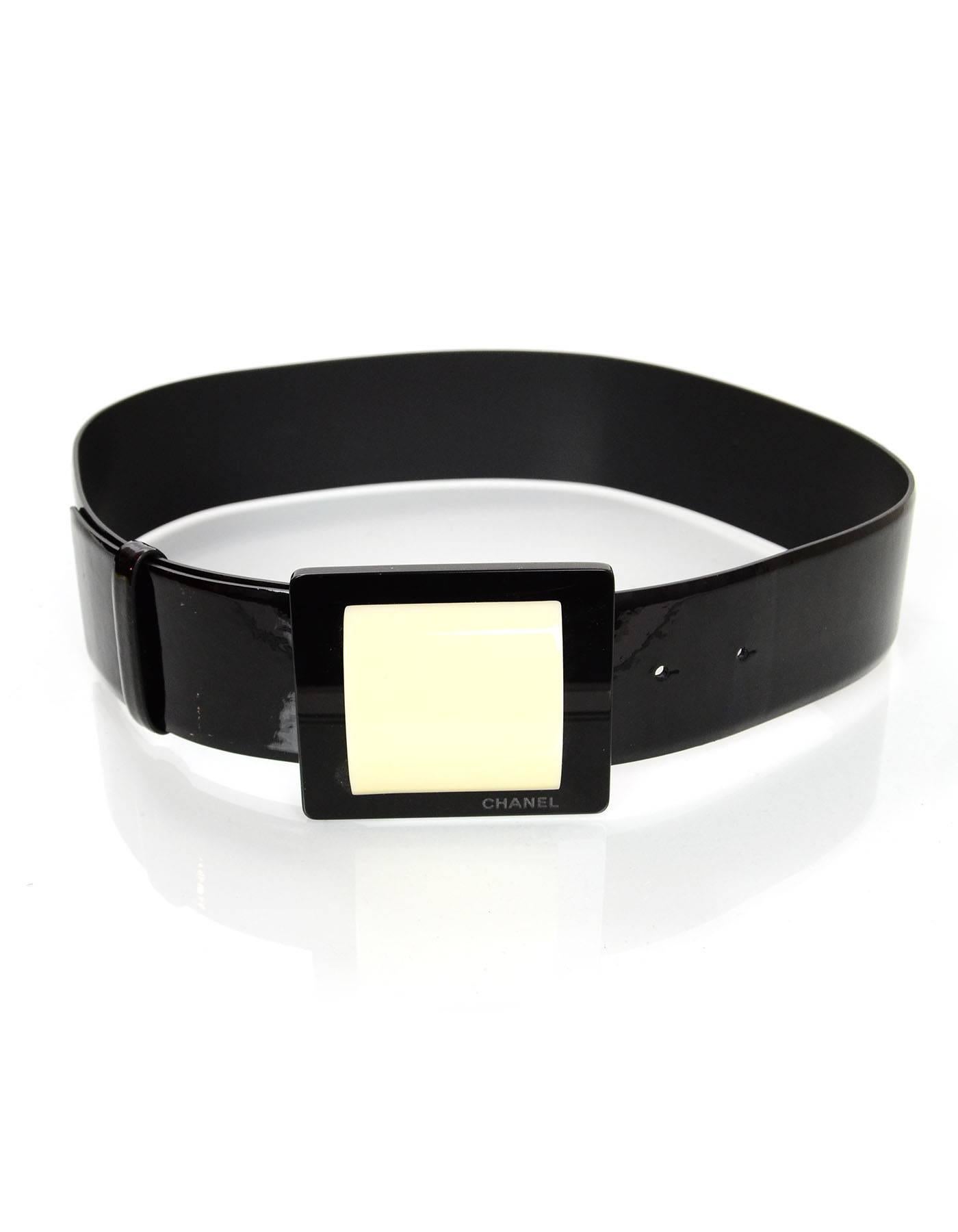 Chanel Black Patent Wide Belt 
Features ivory resin detail on buckle
Year of Production: 2007
Color: Black and ivory
Materials: Patent leather, resin and metal
Closure/Opening: Buckle and notch closure
Stamp: CHANEL
Overall Condition: Excellent