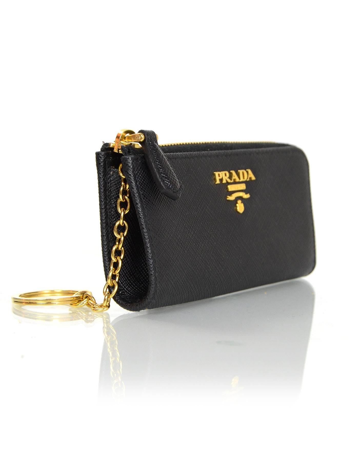 100% Authentic Prada Black Saffiano Leather Keychain Pouch.  

Made In: Italy
Color: Black
Hardware: Goldtone
Materials: Saffiano leather, metal
Lining: Black Leather
Closure/Opening: Zip around
Exterior Pockets: None
Interior Pockets: