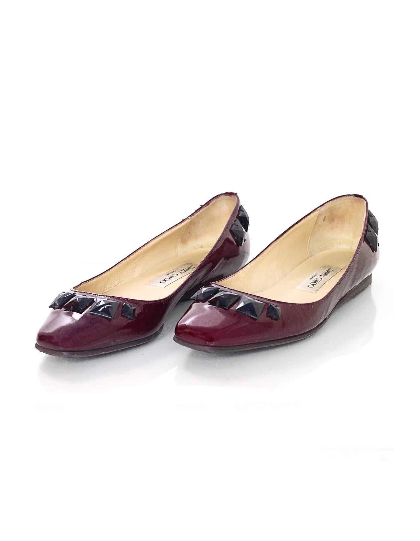 100% Authentic Jimmy Choo Burgundy Flats With Studs. Features burgundy patent leather flats feature black studs, a square toe and rubber sole. Silver Jimmy Choo nameplate on the back heel of the shoe.

Made In: Italy
Color: Burgundy
Materials:
