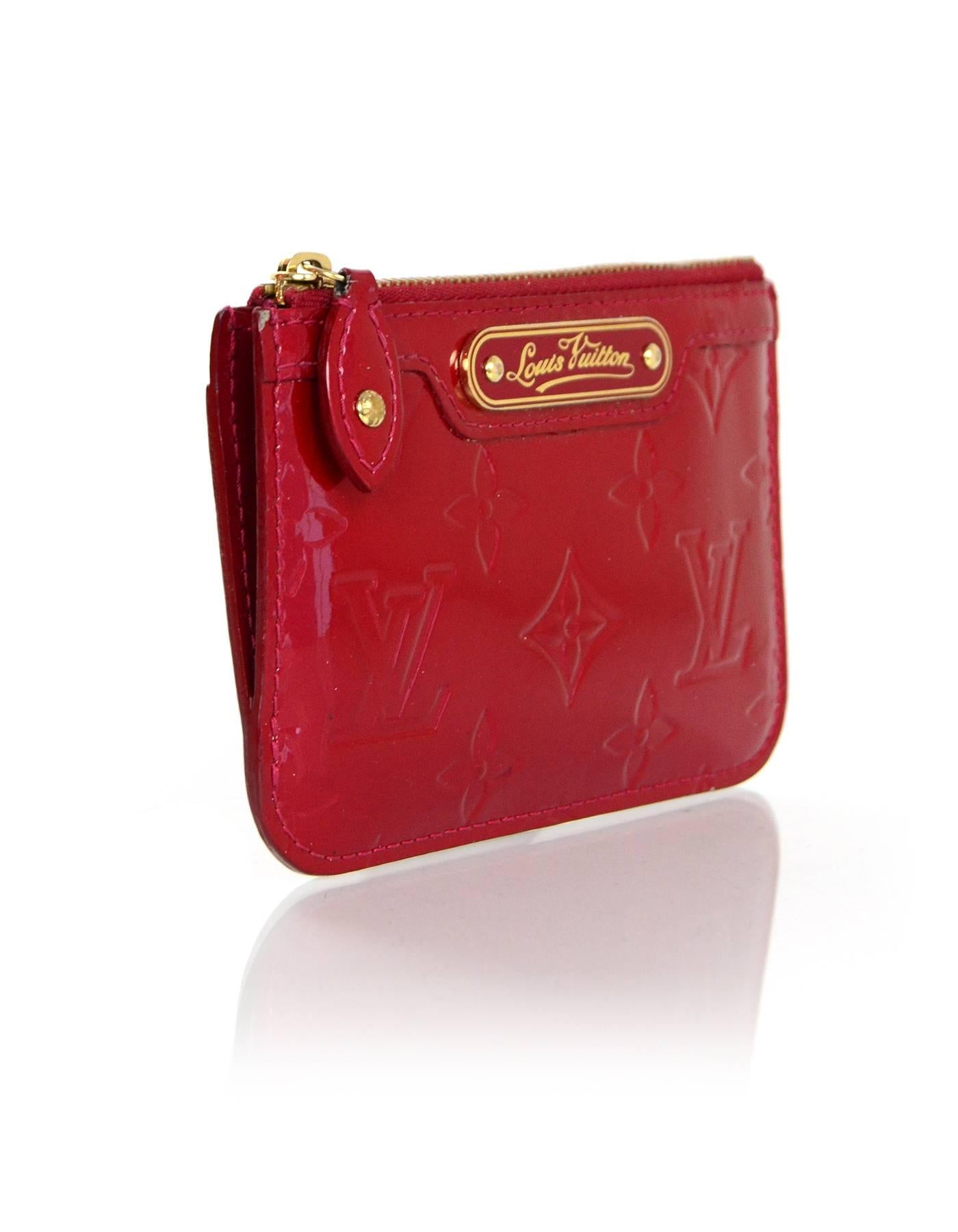 Louis Vuitton Pomme D'Amour Vernis Cles Coin Purse 
Features chain link key ring on interior
Made In: Spain
Year of Production: 2007
Color: Red
Hardware: Goldtone
Materials: Vernis (patent leather)
Lining: Red leather
Closure/Opening: Zip