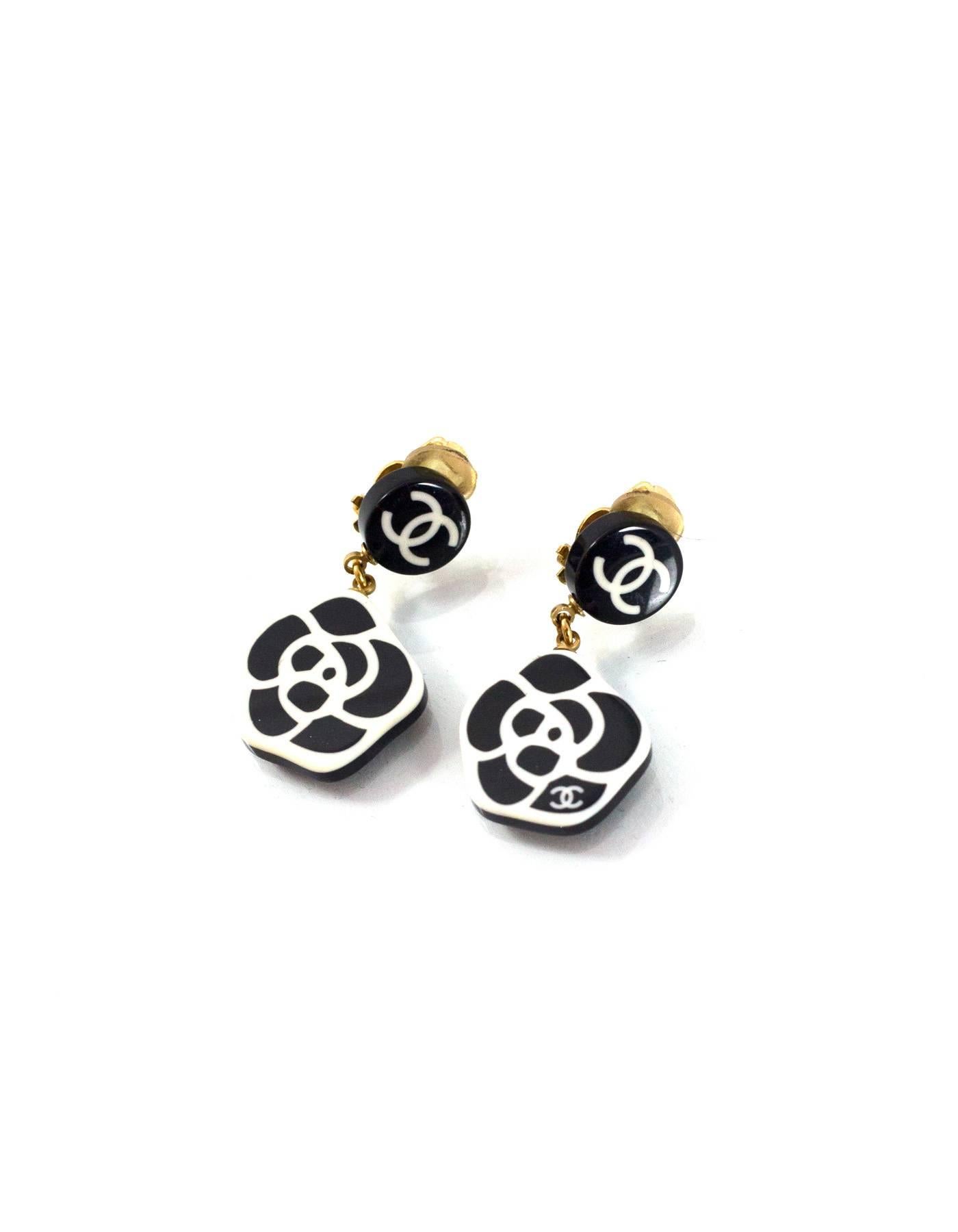 100% Authentic Chanel Black/White Camelia Clip On Earrings. Features resin dangles with white camelia printed on black background. Clip on clasp with CC logo. Includes dust bag. Excellent pre-owned condition with the exception of light scuffs on