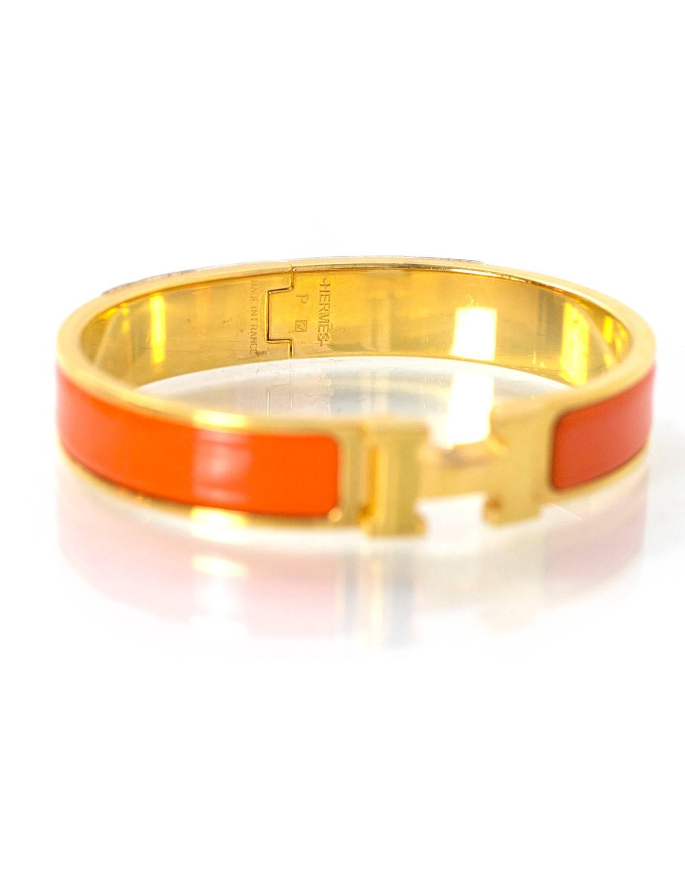 Hermes Orange Enamel & Gold H Clic Clac GM Bangle

Made In: France
Color: Orange and goldtone
Materials: Enamel and metal
Closure: Twist H and hinge
Stamp: Hermes P Made in France
Retail Price: $600 + tax
Overall Condition: Excellent pre-owned