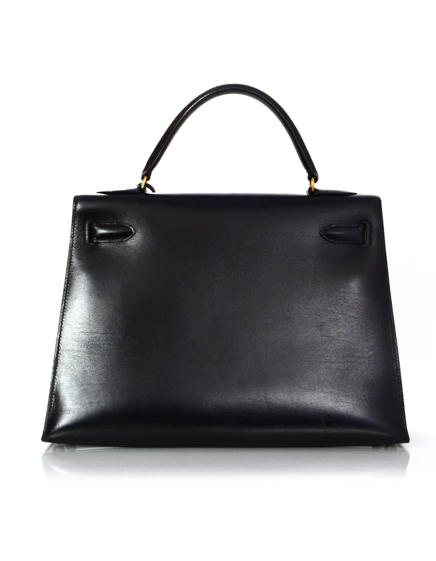 100% Authentic Hermes '80s Black Box Leather 32cm Sellier Rigid Kelly Bag.  Features removable shoulder strap.

Made In: France
Year of Production: 1987
Color: Black
Hardware: Goldtone
Materials: Smooth box leather, metal
Lining: Black chevre