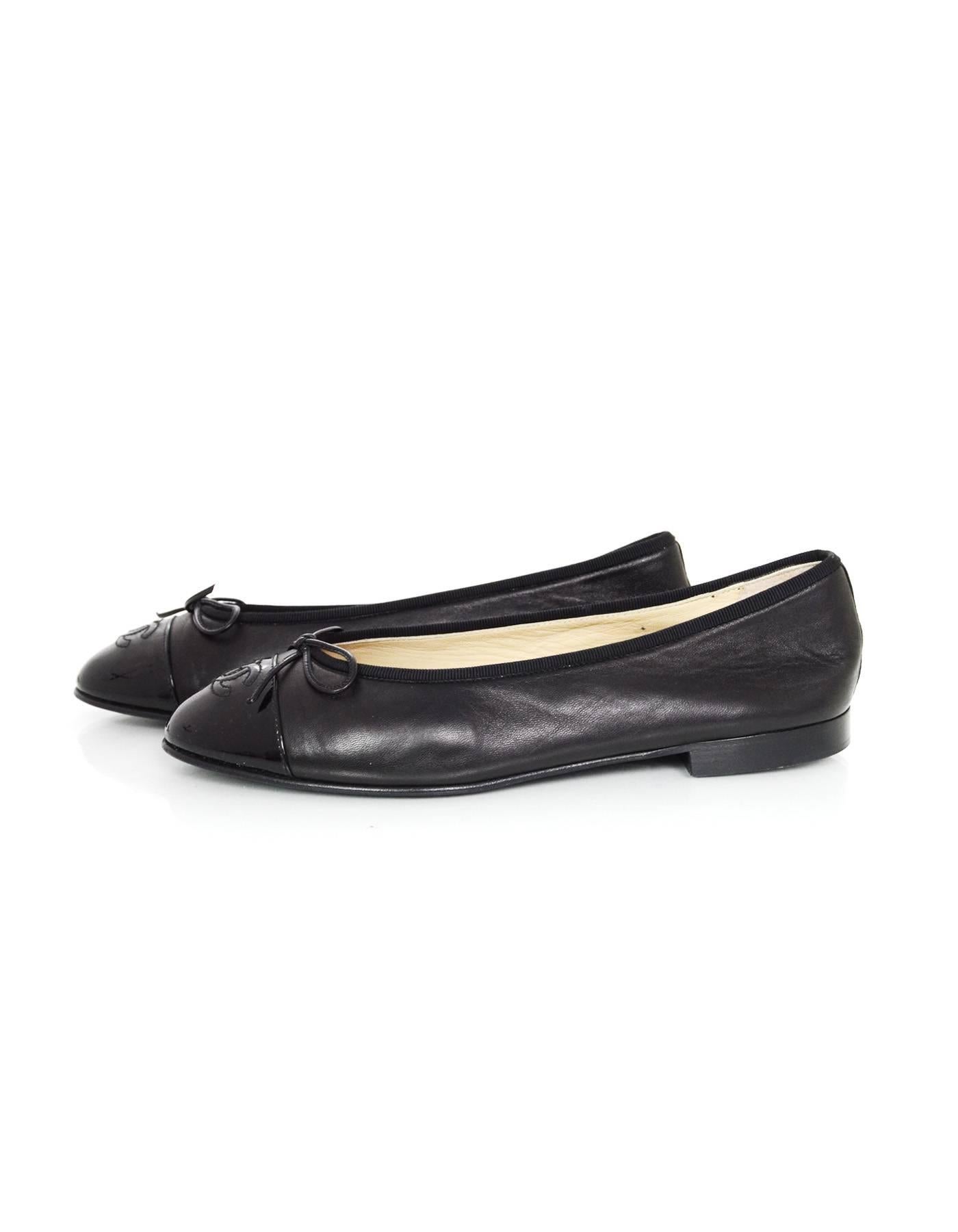 Chanel Black Leather Ballet Flats 
Features patent leather toe cap with CC stitched on top

Made In: Italy
Color: Black
Materials: Leather and patent leather
Closure/Opening: Slide on
Sole Stamp: CC Made in Italy 39 1/2
Overall Condition: Excellent