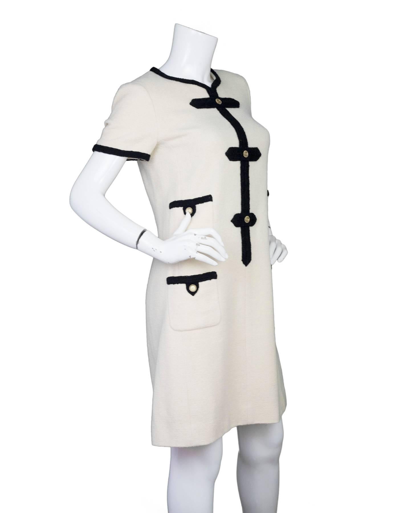 Chanel Cream & Black Wool Shift Dress 
Features chain link button details and black trim throughout

Made In: France
Year of Production: 2005
Color: Cream and black
Composition: 97% wool, 3% nylon
Lining: Cream, 100% silk
Closure/Opening: Back