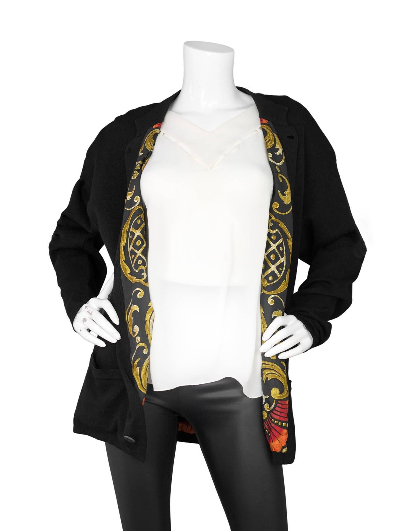 Hermes Black Cotton Knit Cardigan Sweater 
Features multi-color printed silk lining

Color: Black
Composition: Believed to be a cotton-blend
Lining: Multi-colored silk-blend
Closure/Opening: Front button down closure
Exterior Pockets: Two hip patch