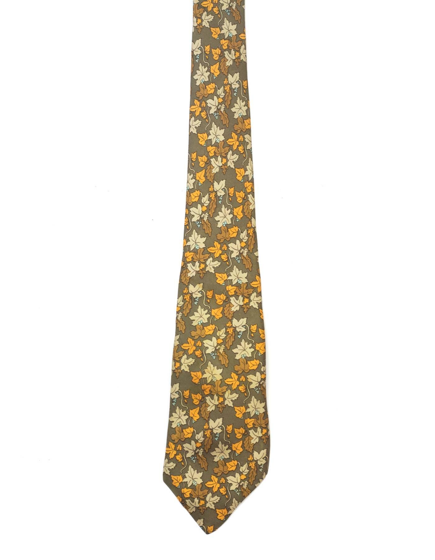 Hermes Olive Autumn Leaves Printed Silk Tie
Features grapevines printed throughout

Made In: France
Color: Olive green, orange, grey and blue
Composition: 100% silk
Overall Condition: Excellent pre-owned condition with the exception of a small mark
