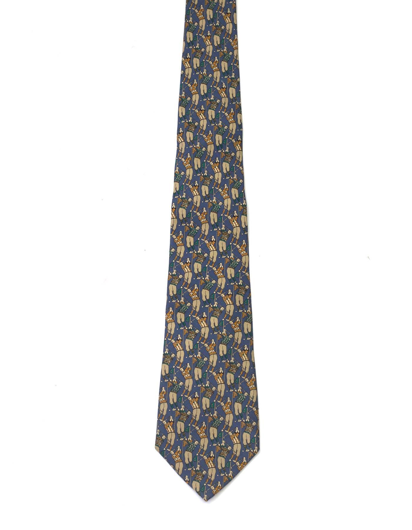 Salvatore Ferragamo Blue Golf Print Silk Tie
Features men in green and yellow argyle sweaters playing golf printed throughout

Made In: Italy
Color: Grey-blue, green,yellow and taupe
Composition: 100% silk
Overall Condition: Excellent pre-owned