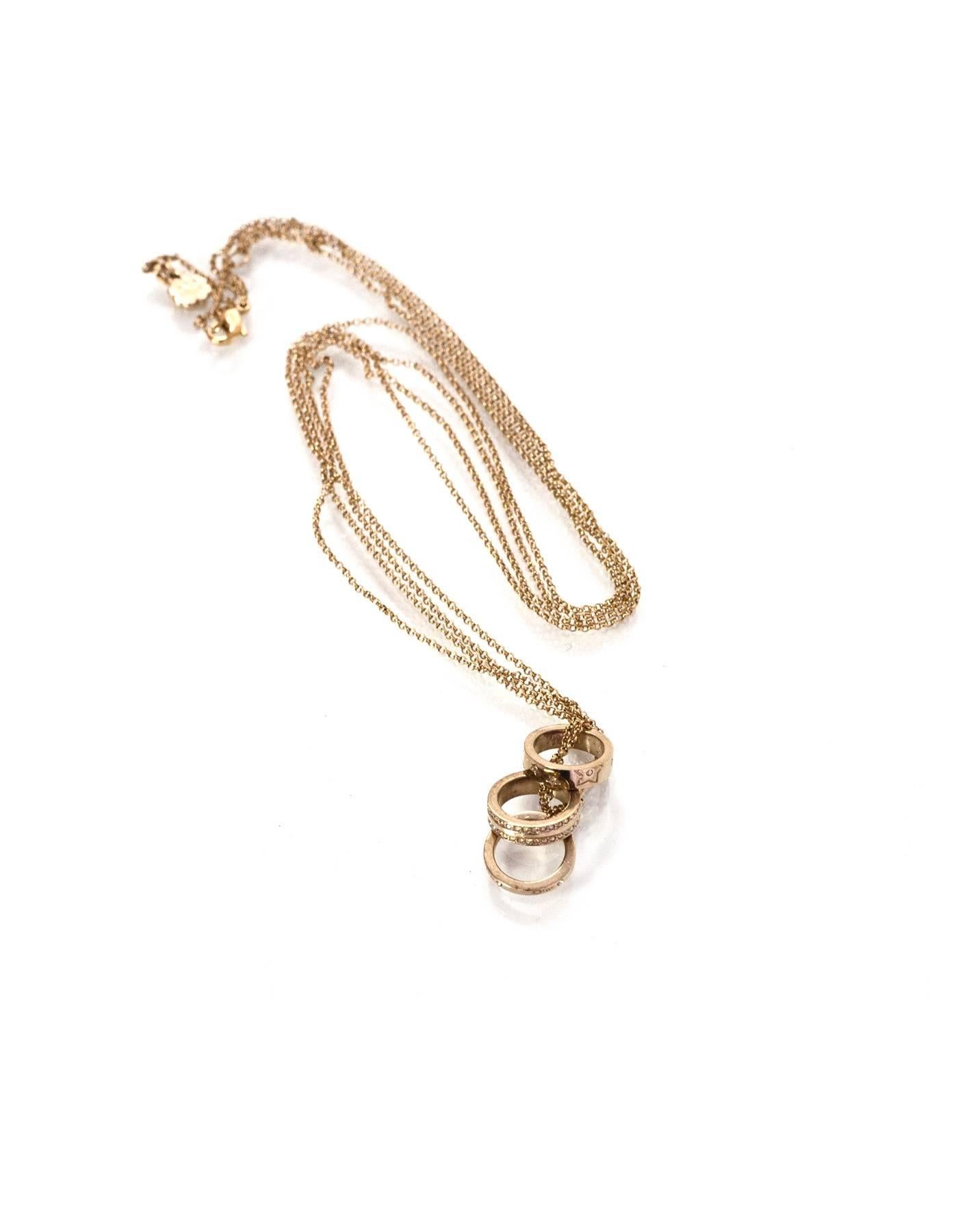 Christian Dior Gold Double Chain 3 Ring Necklace 
Features 3 rings with crystals, stars and dior logo

Color: Goldtone
Materials: Metal and crystal
Closure: Lobster claw clasp
Stamp: Dior
Overall Condition: Excellent pre-owned condition with the