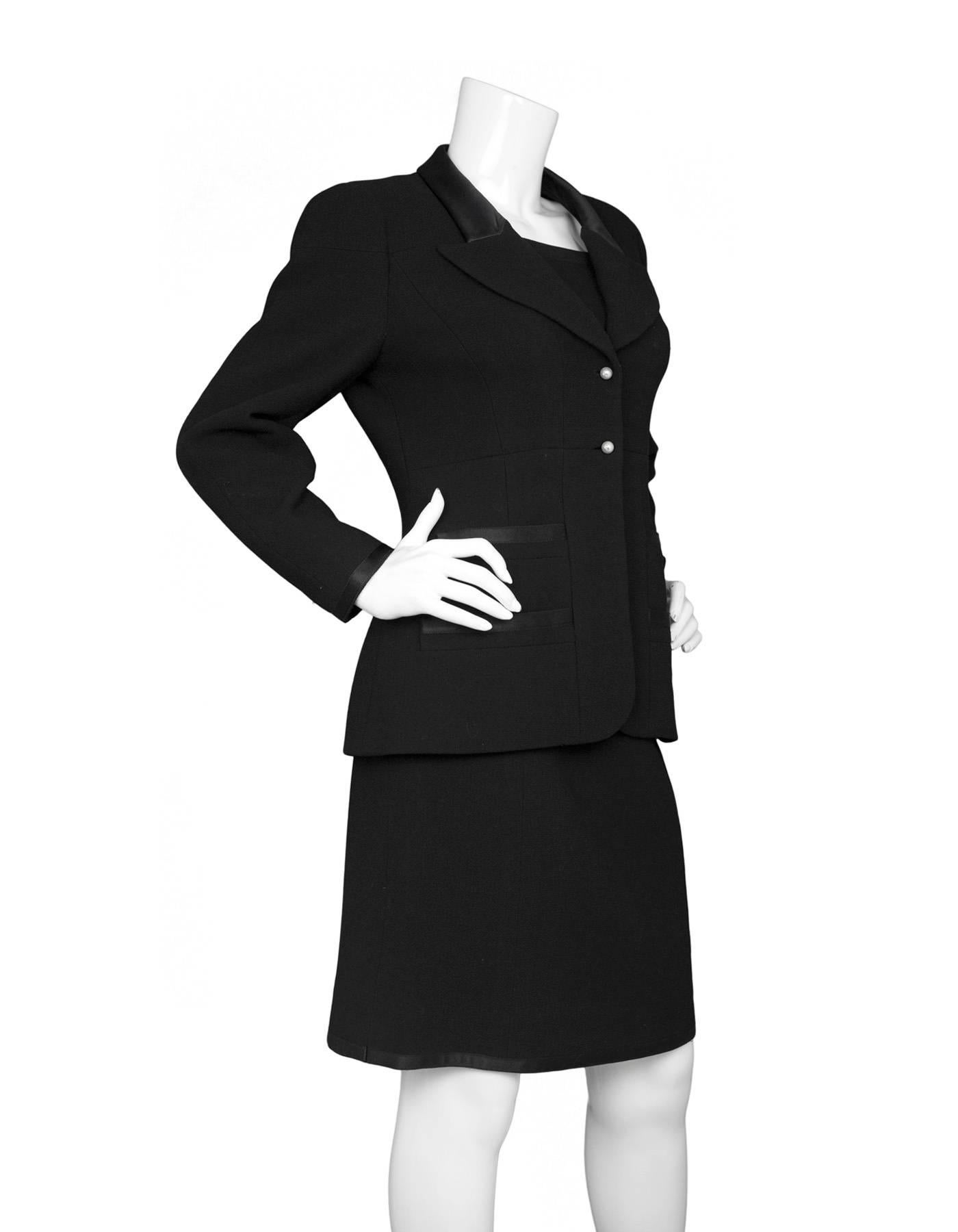 Chanel Black Wool 2 Piece Skirt Suit 
Features satin trim throughout and pearl buttons with CC's on jacket

Made In: France
Year of Production: 1997
Color: Black
Composition: 100% wool
Lining: Black, 95% silk, 5% spandex
Closure/Opening: Jacket-