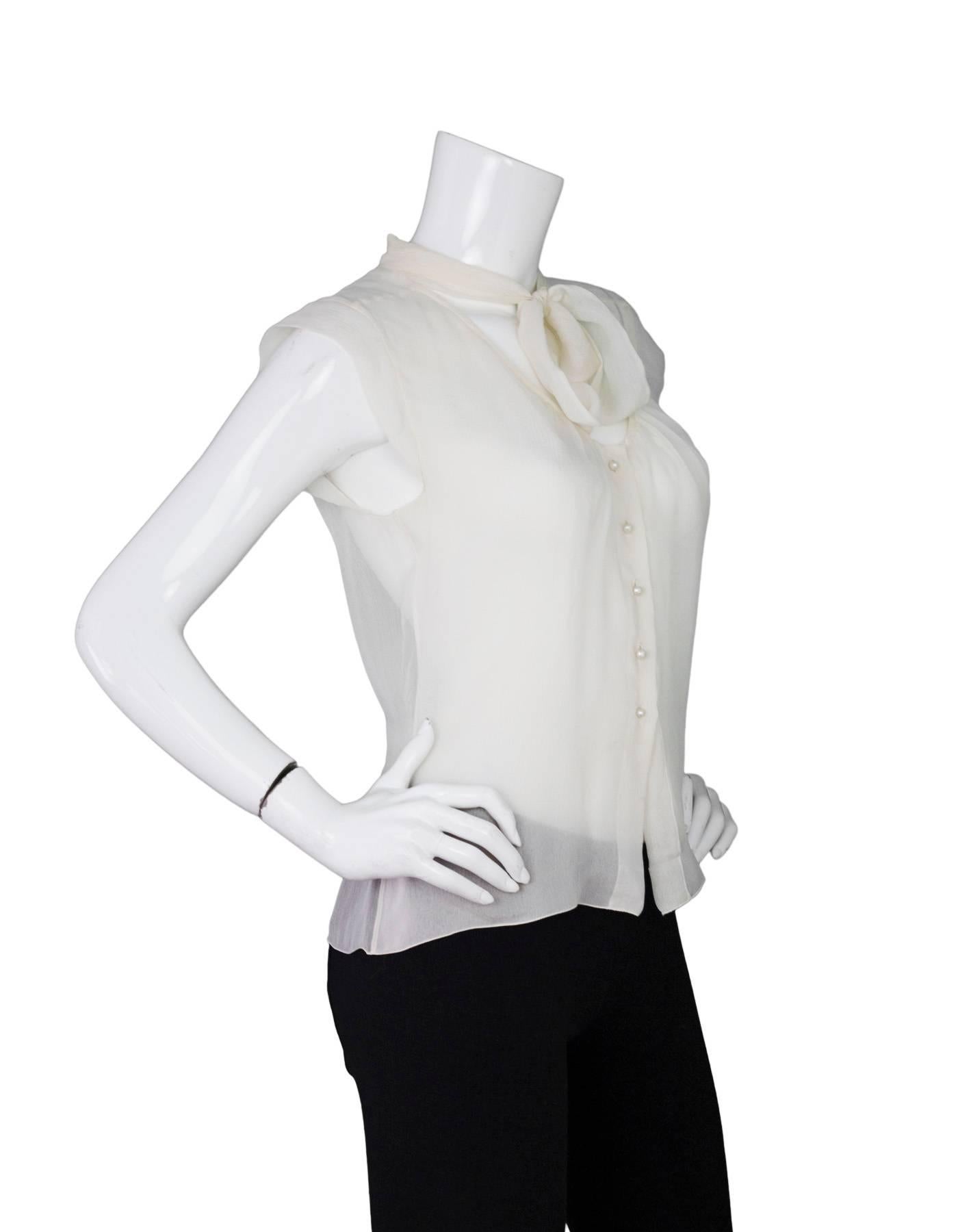 Chanel Ivory Silk Sheer Blouse 
Features tie at neckline and small faux pearl CC buttons

Color: Ivory
Composition: Not given- believed to be 100% silk
Lining: None
Closure/Opening: Pull over
Exterior Pockets: None
Interior Pockets: None
Overall