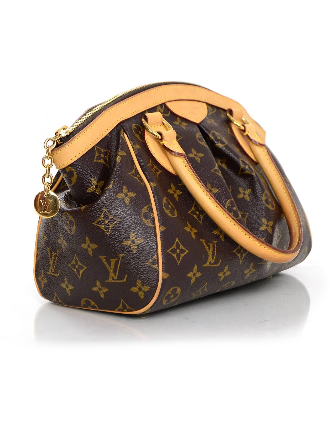 Louis Vuitton Monogram Tivoli PM Bag

Made In: U.S.A
Year of Production: 2009
Color: Brown
Hardware: Goldtone
Materials: Coated canvas and vachetta leather
Lining: Brown textile
Closure/Opening: Zip top with goldtone chain and LV logo charm
Exterior