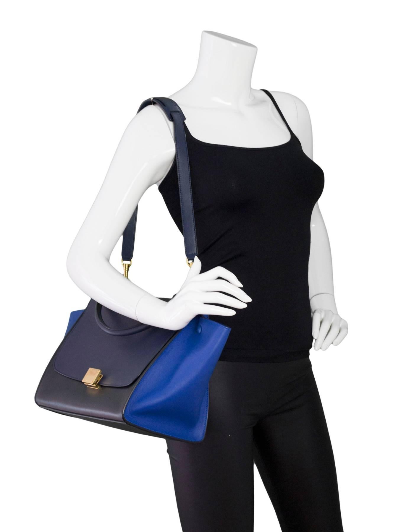 Celine Tri-Color Leather Trapeze Bag 

Color: Black, royal blue, navy
Hardware: Goldtone
Materials: Leather, metal
Lining: Navy leather
Closure/Opening: Flap top with twist lock and push lever closure
Exterior Pockets: Zip pocket at back
Interior