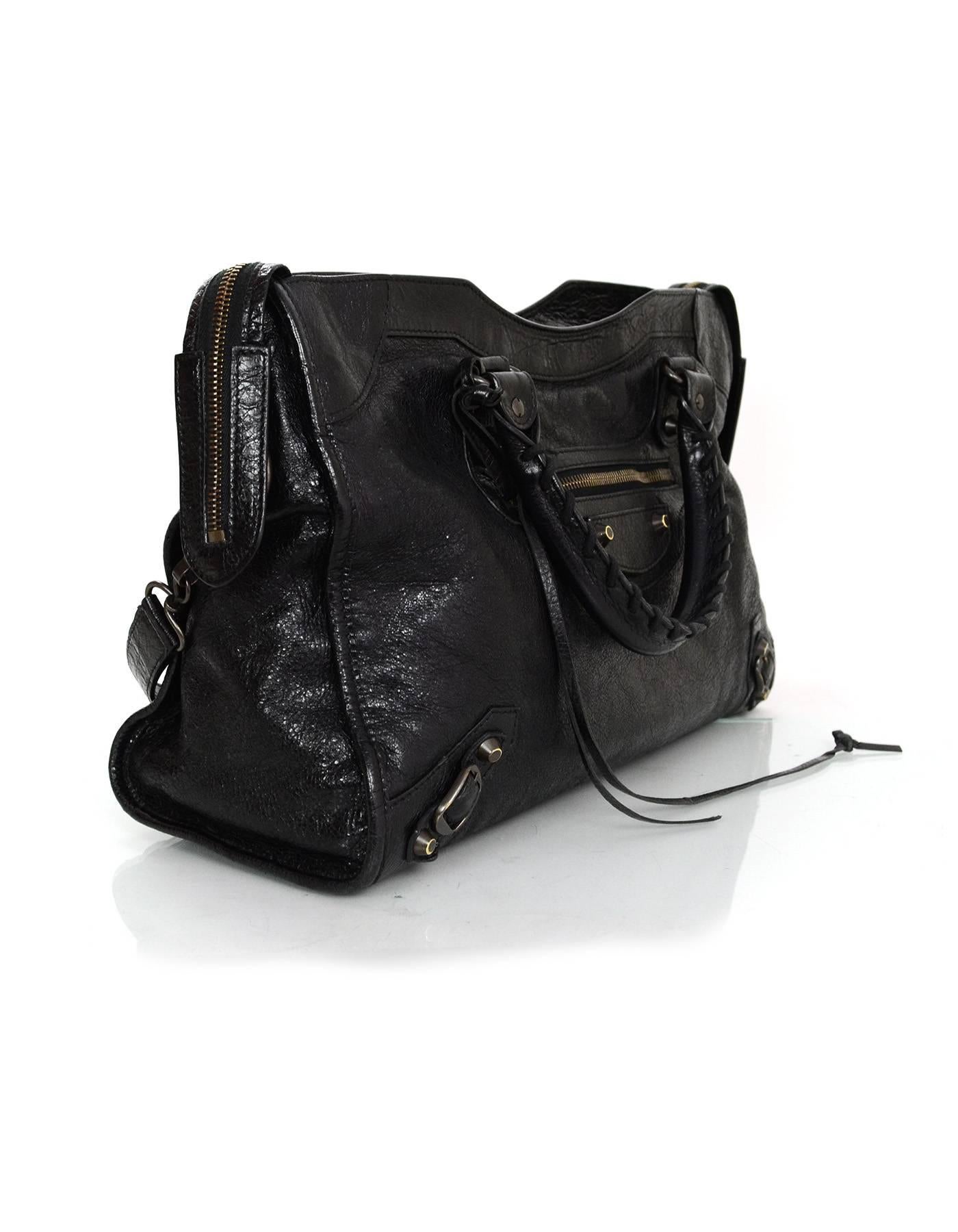 Balenciaga Black Classic City Bag
Features optional shoulder/crossbody strap

Made In: Italy
Year Of Production: 2014
Color: Black
Hardware: Bronze
Materials: Distressed leather
Lining: Black cotton
Closure/Opening: Double zip top
Exterior Pockets:
