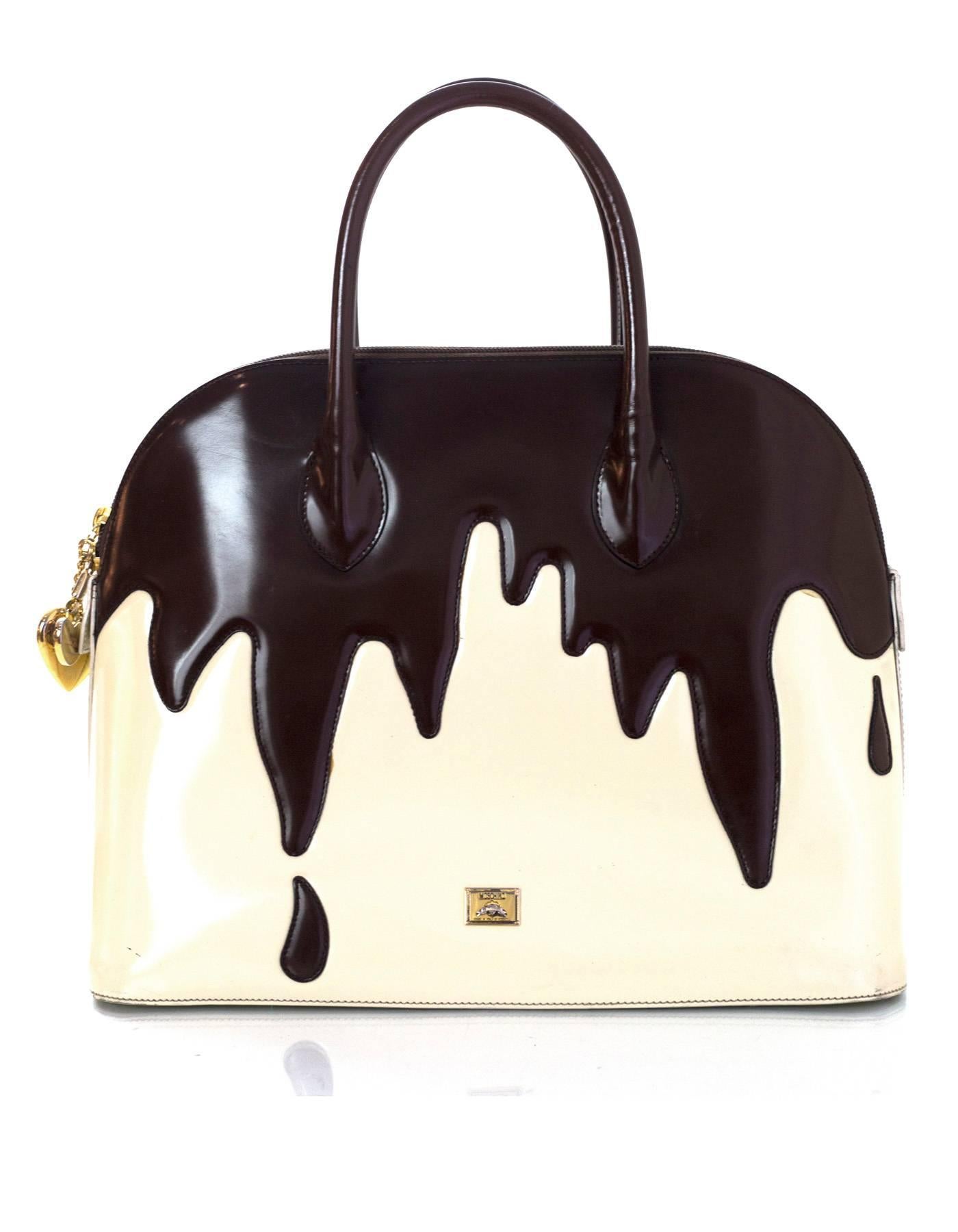 Moschino Dripping Chocolate Handle Bag 
Features optional strap and heart charm zipper pull

Made In: Italy
Color: Brown, ivory
Interior Lining: Black printed textile
Hardware: Goldtone
Materials: Glazed leather, metal
Closure/Opening: Double zip