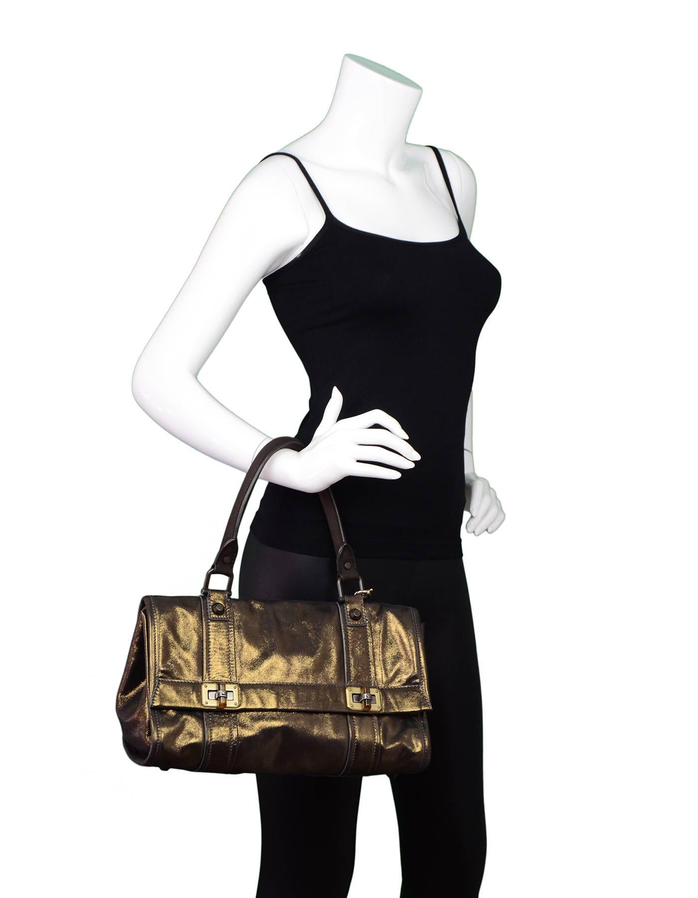 Lanvin Gold Iridescent Handle Bag

Made In: Italy
Color: Gold
Hardware: Brass
Materials: Leather, metal
Lining: Black canvas
Closure/Opening: Flap top with twist lock at each side
Exterior Pockets: None
Interior Pockets: One zip wall pocket
Overall