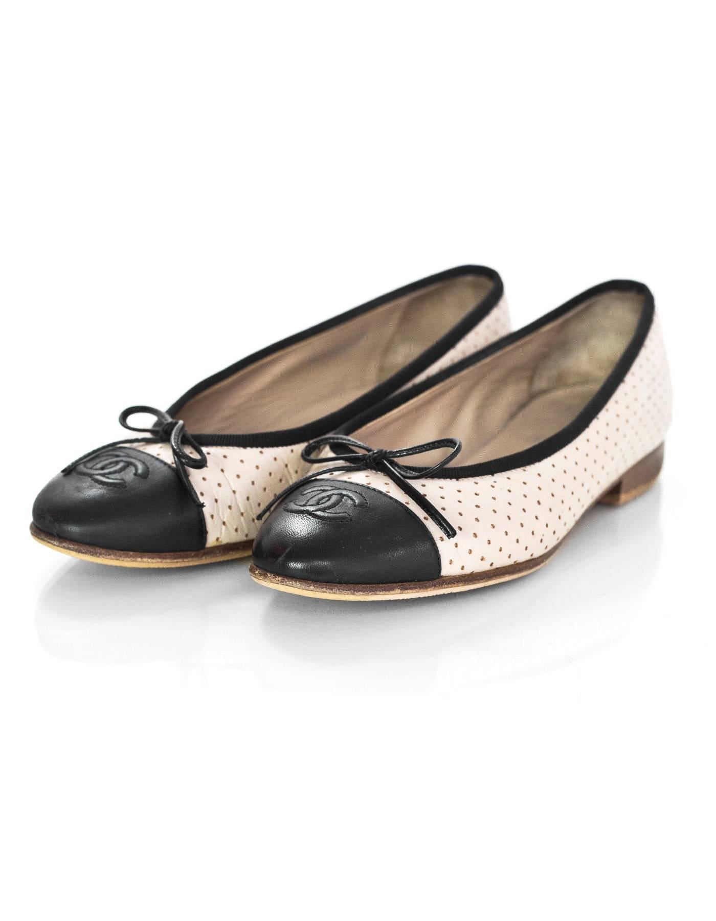 Chanel Beige & Black Perforated Ballet Flats Sz 36

Made In: Italy
Color: Beige, black
Materials: Leather
Closure/Opening: Slide on
Sole Stamp: CC Made in Italy 36
Current Retail: $750+ tax
Overall Condition: Very good pre-owned condition with