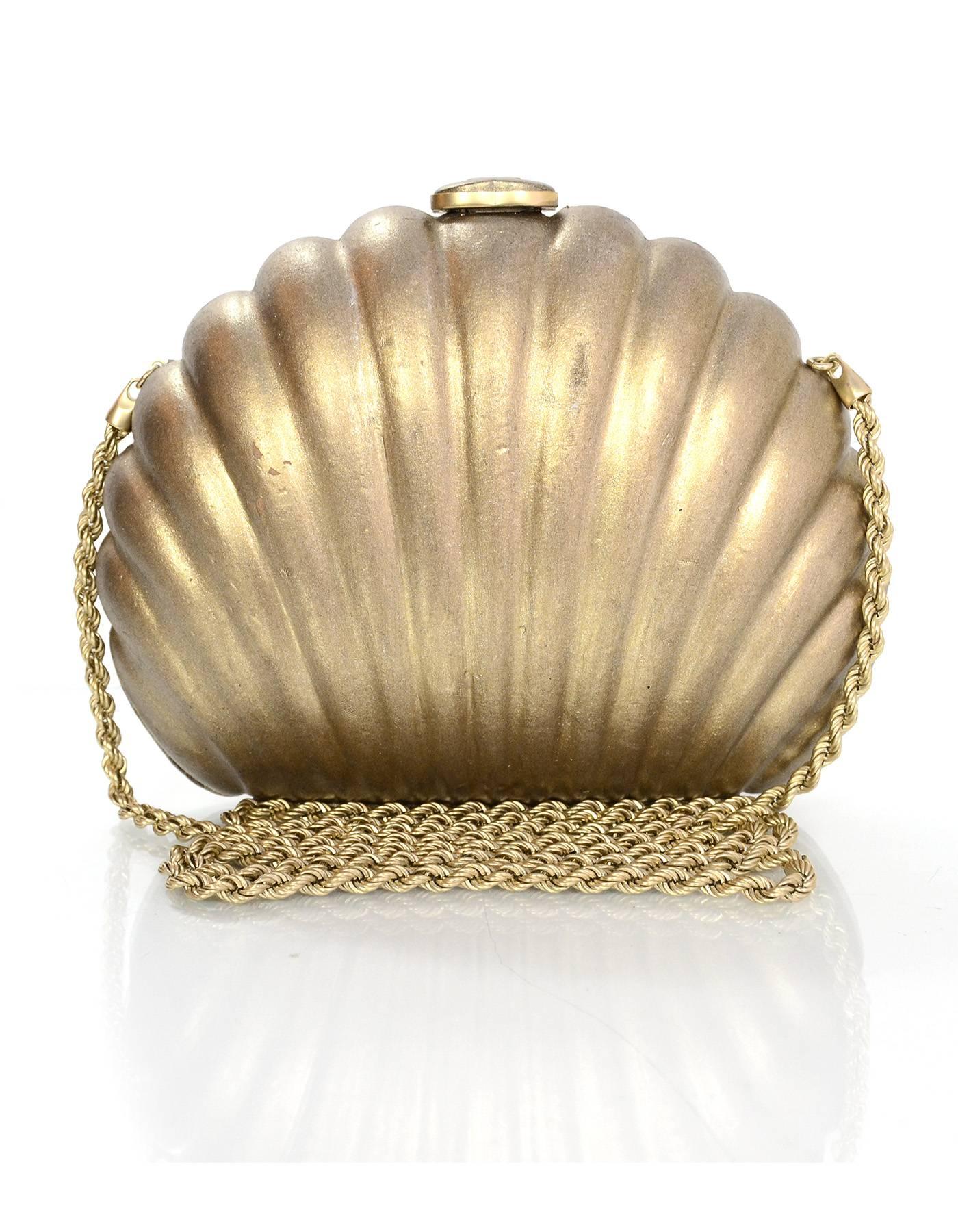 Chanel Gold Seashell Evening Bag 
Features optional crossbody strap

Made In: Italy
Year of Production: 2010-2011
Color: Metallic gold
Hardware: Goldtone
Materials: Leather
Lining: Pink satin
Closure/Opening: Frame bag style push button hinged