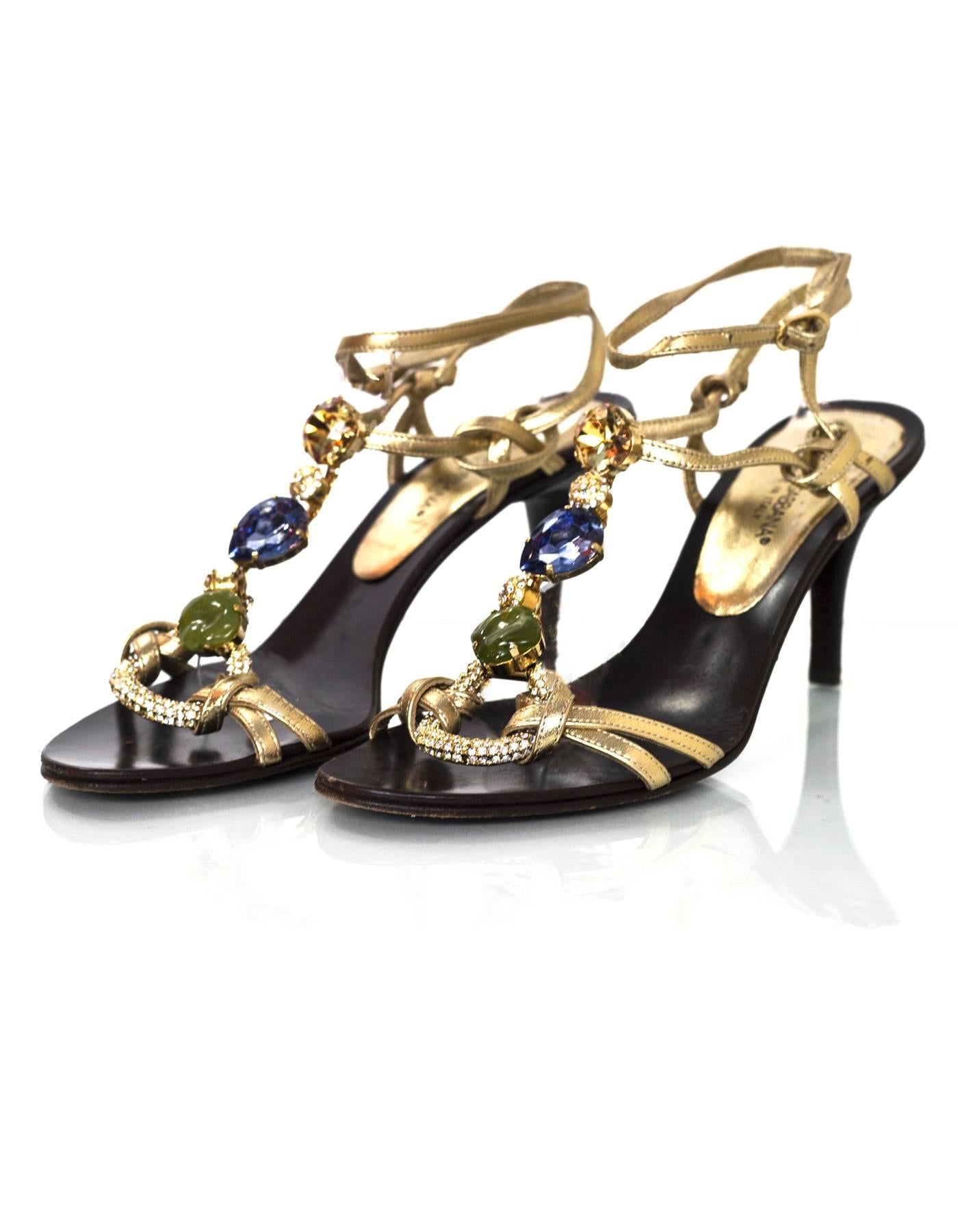 Dolce & Gabbana Jeweled T-Strap Sandals Sz 36.5

Made In: Italy
Color: Gold
Materials: Leather, pave crystal, stones
Closure/Opening: Buckle closure at ankle
Sole Stamp: Dole & Gabbana Vero Cuoio Made in Italy 36.5
Overall Condition: