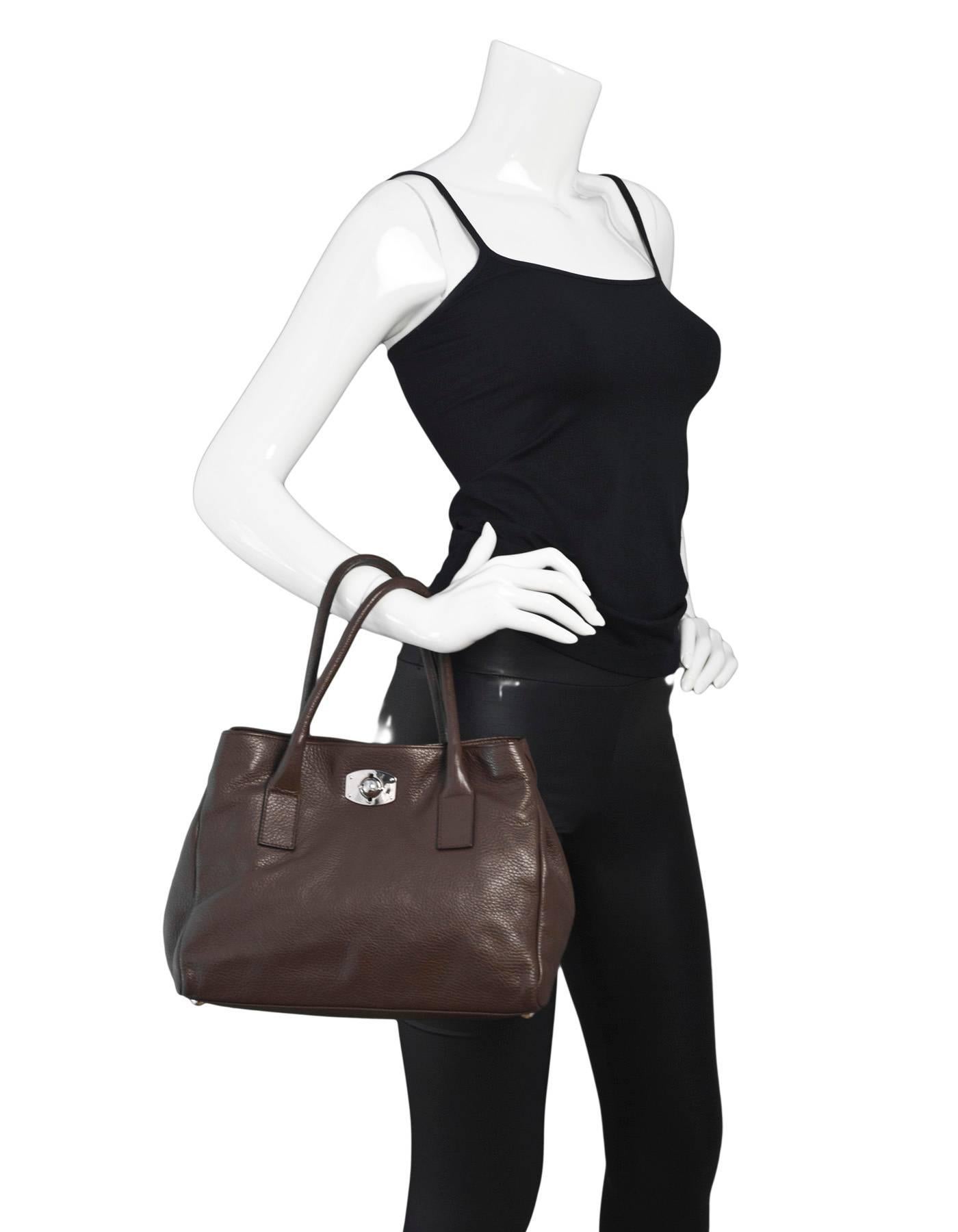 Furla Brown Leather Tote

Made In: Tunisia
Color: Brown
Hardware: Silvertone
Materials: Leather, metal
Lining: Brown textile
Closure/Opening: Front twist lock
Exterior Pockets: None
Interior Pockets: One zip pocket
Overall Condition: Excellent