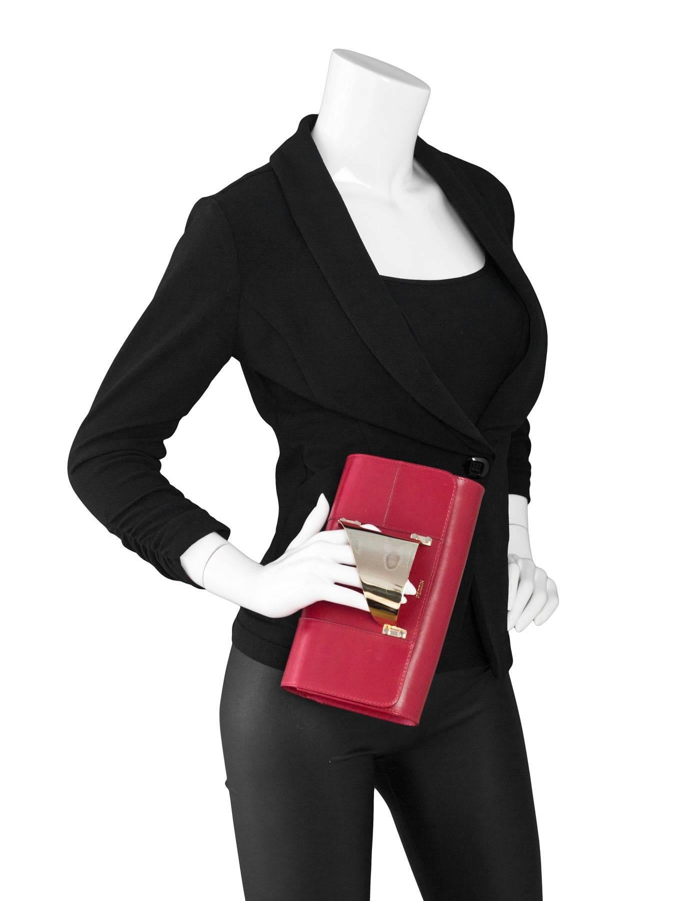Perrin Red Leather L'Eiffel Glove Clutch
To be worn with right hand

Color: Red, gold
Materials: Leather, metal
Lining: Red lambskin leather
Closure/opening: Flap top with magnetic closure
Exterior Pockets: None
Interior Pockets: One wall