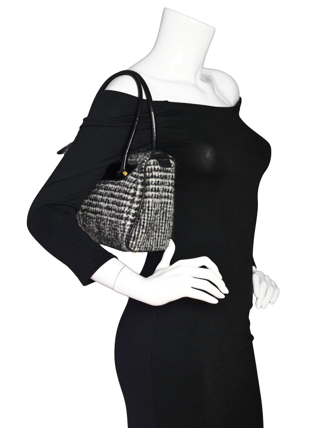 Dolce & Gabbana Black & White Tweed Herringbone Handbag

Made In: Italy
Color: Black, white
Hardware: Goldtone 
Materials: Tweed, patent leather
Lining: Leopard canvas
Closure/Opening: Zip closure
Exterior Pockets: None
Interior Pockets: Zip wall