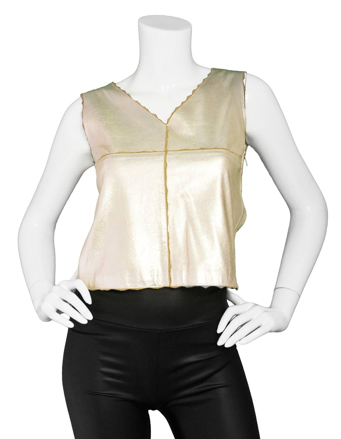 Chanel Metallic Gold Leather Shell Top
Fabric scalloped edges throughout exterior

Made In: France
Year of Production: 2000
Color: Metallic gold
Composition: 100% goatskin
Lining: Gold, 100% silk
Closure/Opening: Hidden side zip up
Exterior Pockets:
