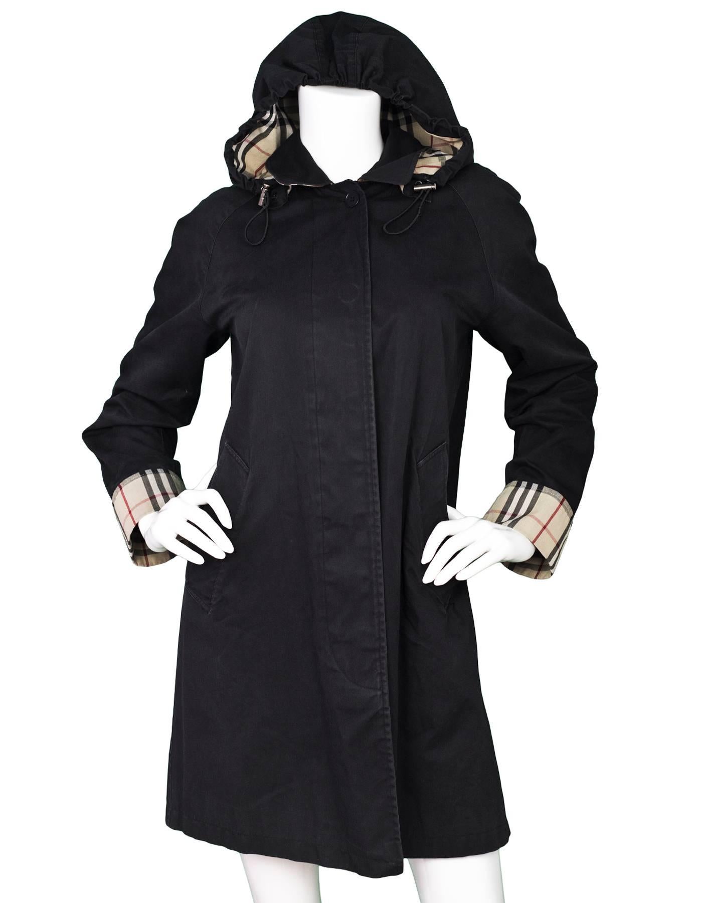 Burberry Black Raincoat with Nova Check Lining

Color: Black
Composition: 100% cotton, 
Lining: Signature nova check
Closure/Opening: Front button closure
Exterior Pockets: Two hip pockets
Interior Pockets: None
Overall Condition: Very good